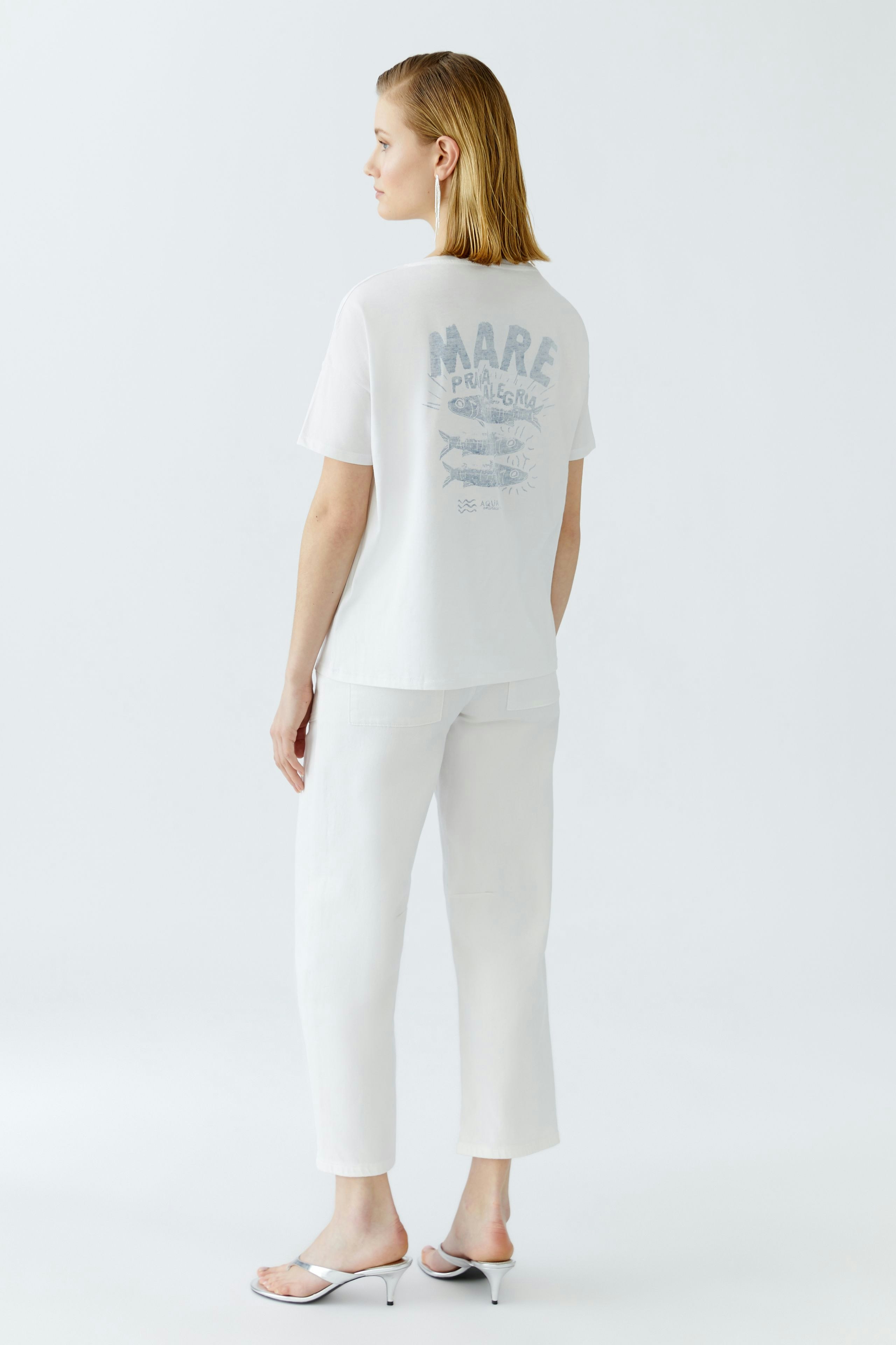 Damen-T-Shirt: Junge Frau trägt ein weißes T-Shirt mit grafischem Druck auf der Rückseite.