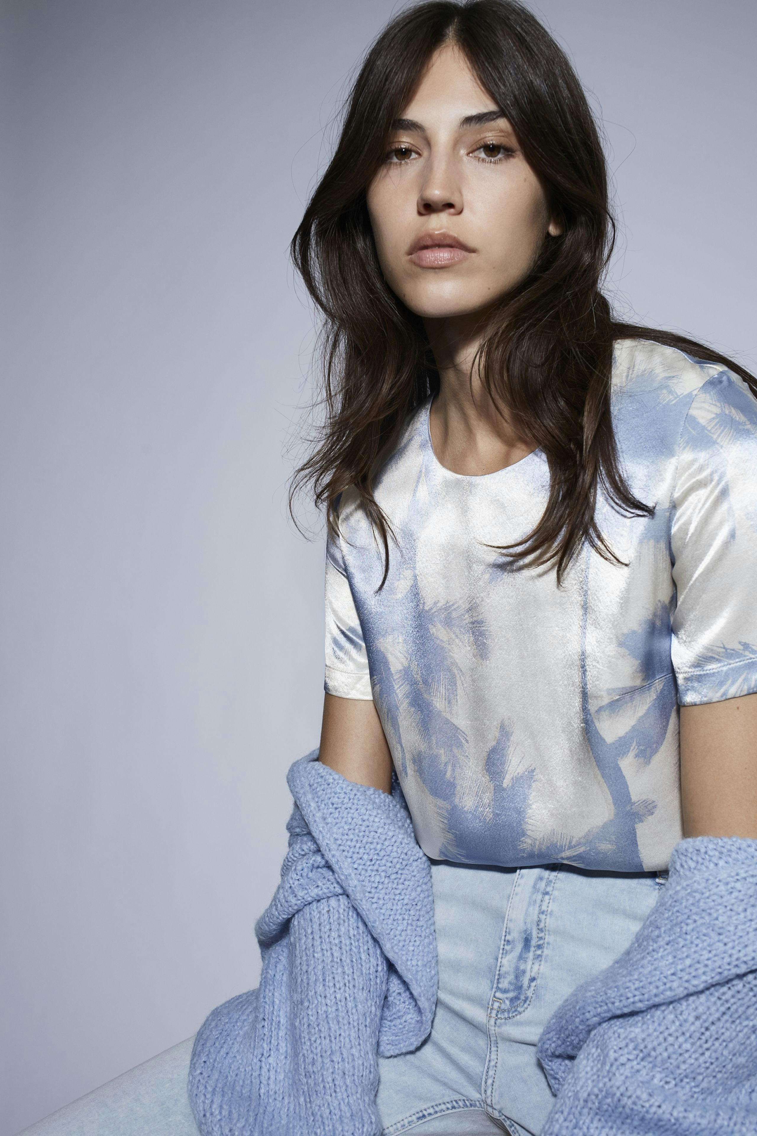 Casual women's blouse: Woman in a light blue blouse with a relaxed fit, paired with a cozy cardigan.