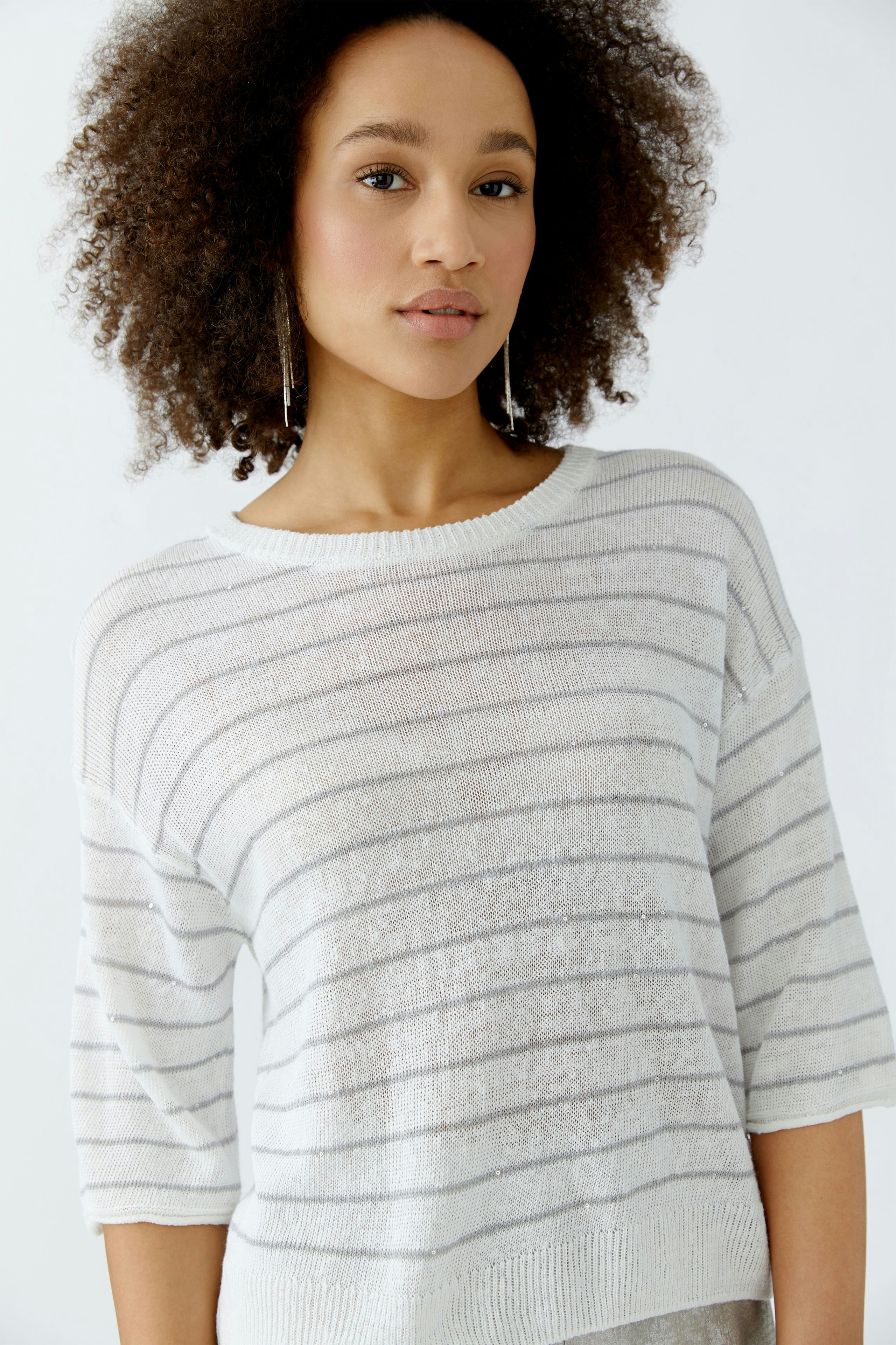 Damen-Pullover: Frau in gestreiftem, leichtem Pullover mit kurzen Ärmeln und lässigem Schnitt.