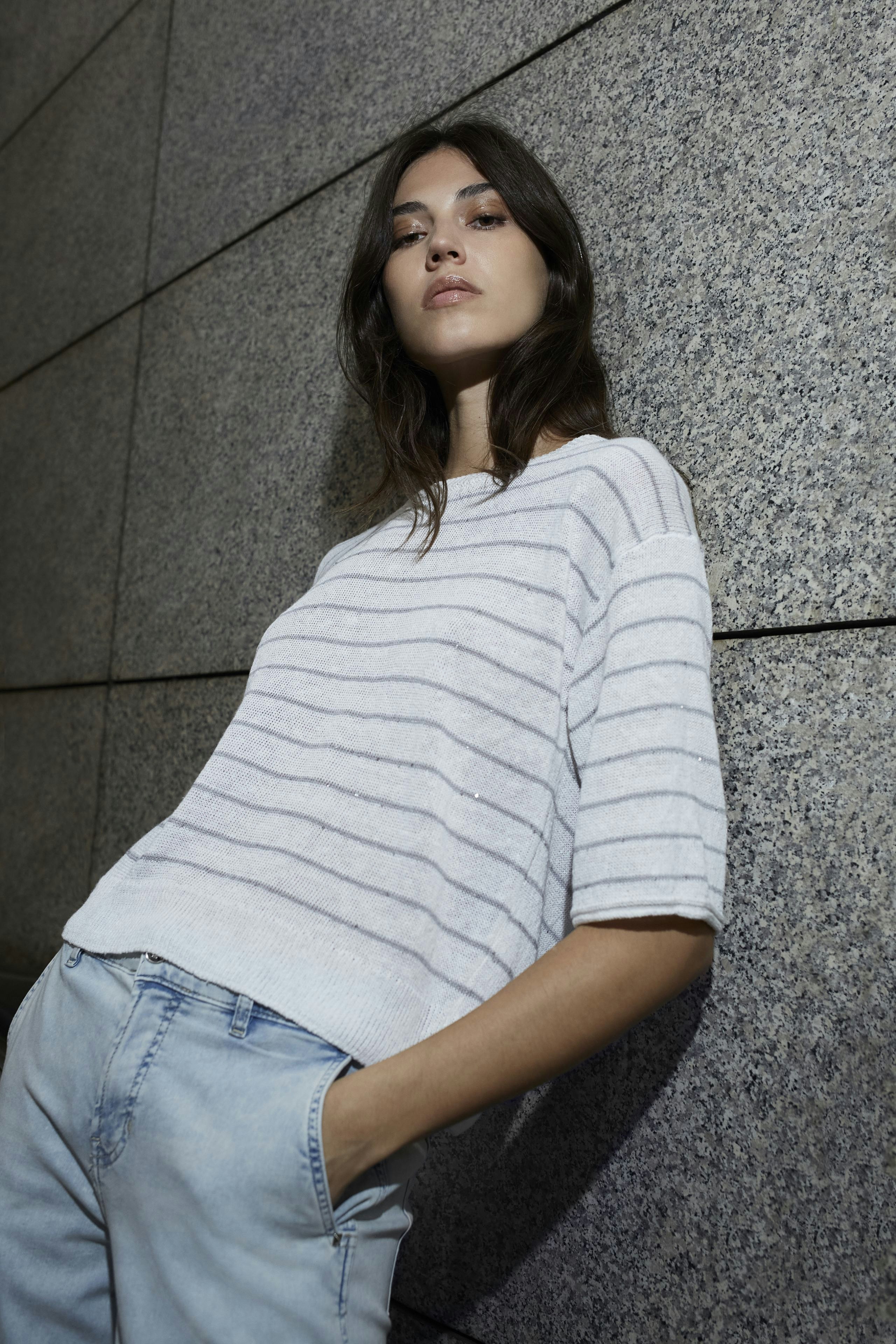 Damen-Pullover: Frau in gestreiftem, lässigem Pullover mit kurzen Ärmeln und lockerer Passform.