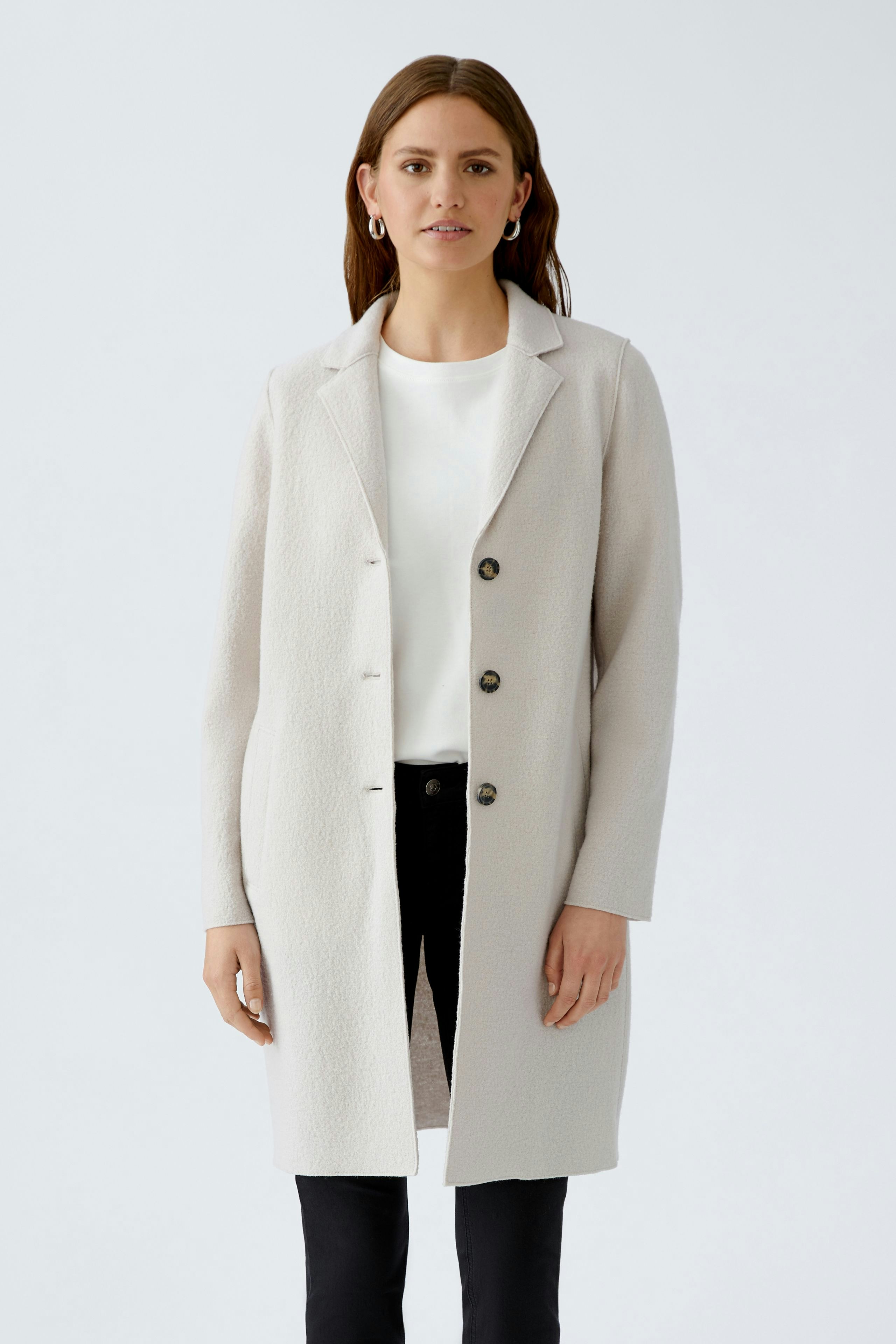 Modern women's wool coat: A woman in a light gray coat with buttons, paired with a simple top and pants.