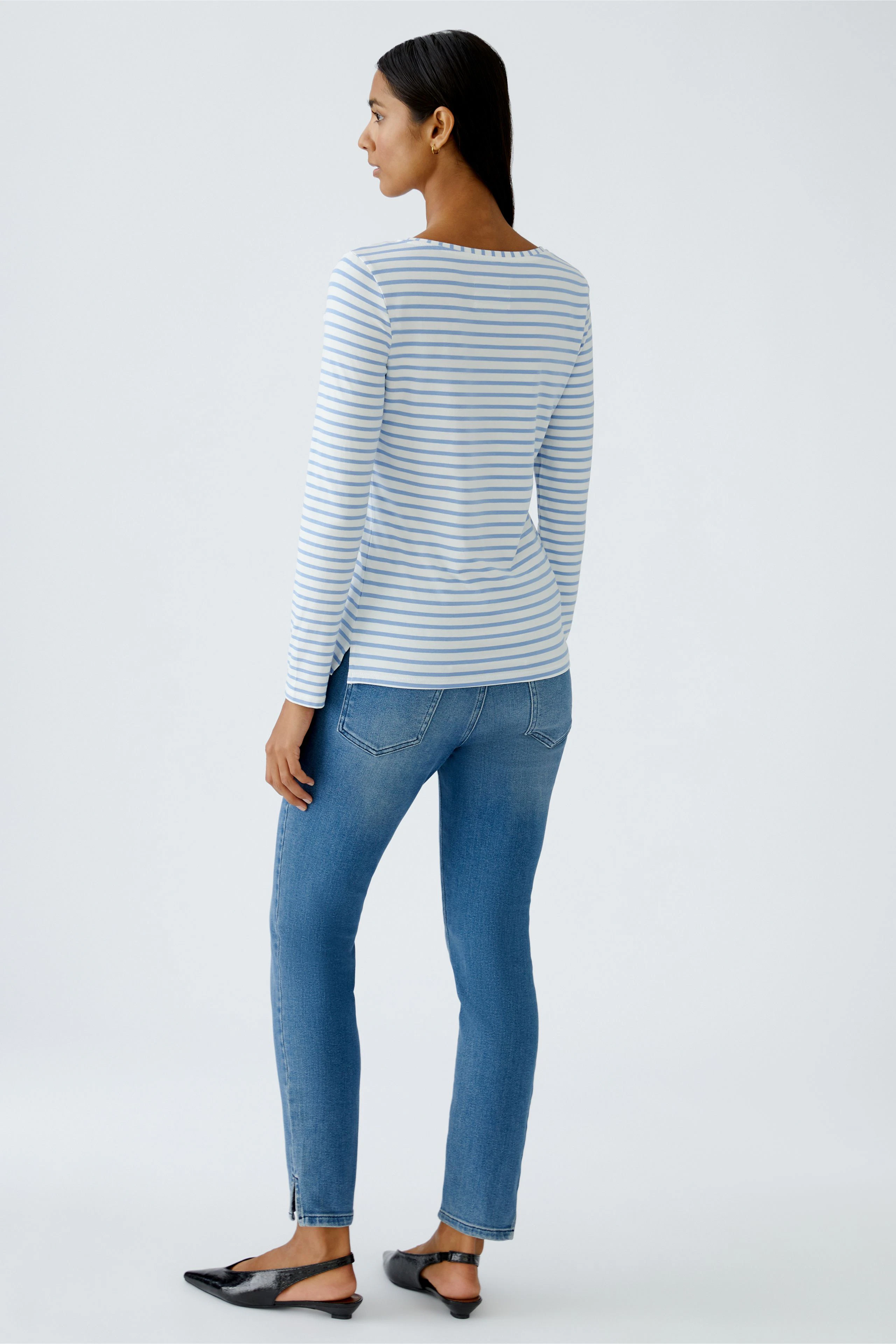 Damen Langarmshirt: Frau trägt gestreiftes Shirt mit langen Ärmeln und lässigen Jeans.