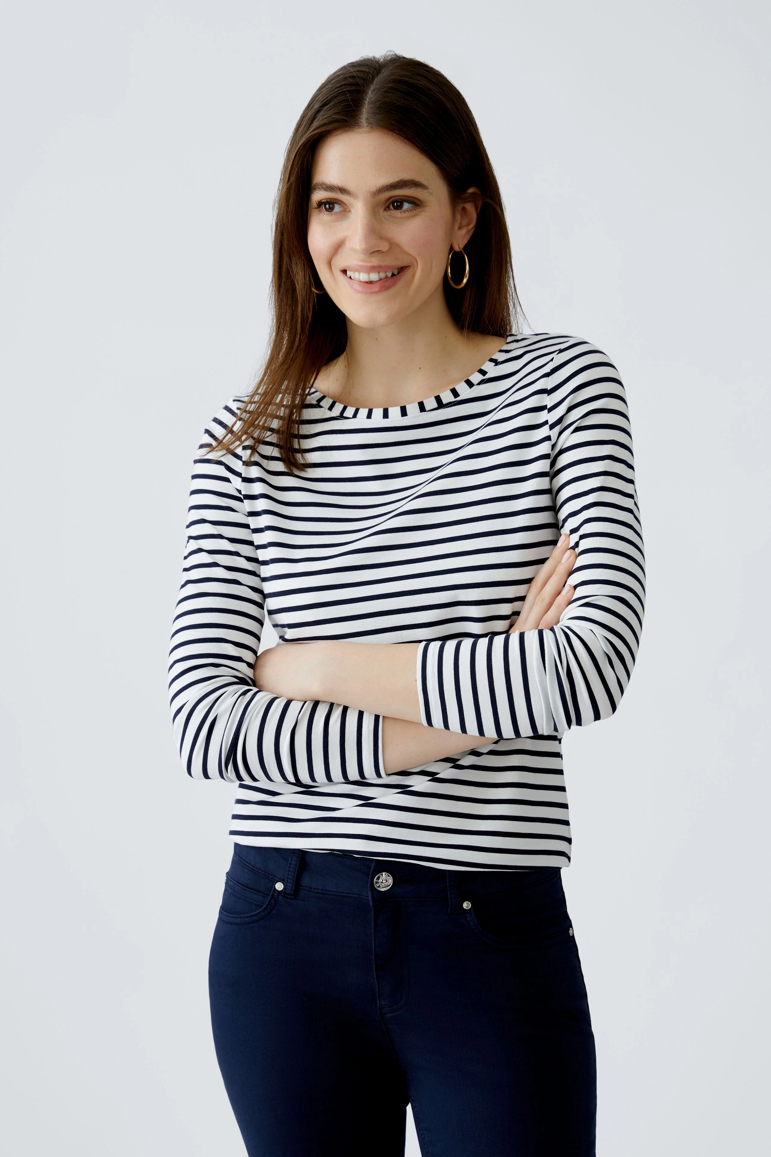 Damen Langarmshirt: Frau in gestreiftem Shirt mit Rundhalsausschnitt und lässiger Ausstrahlung.