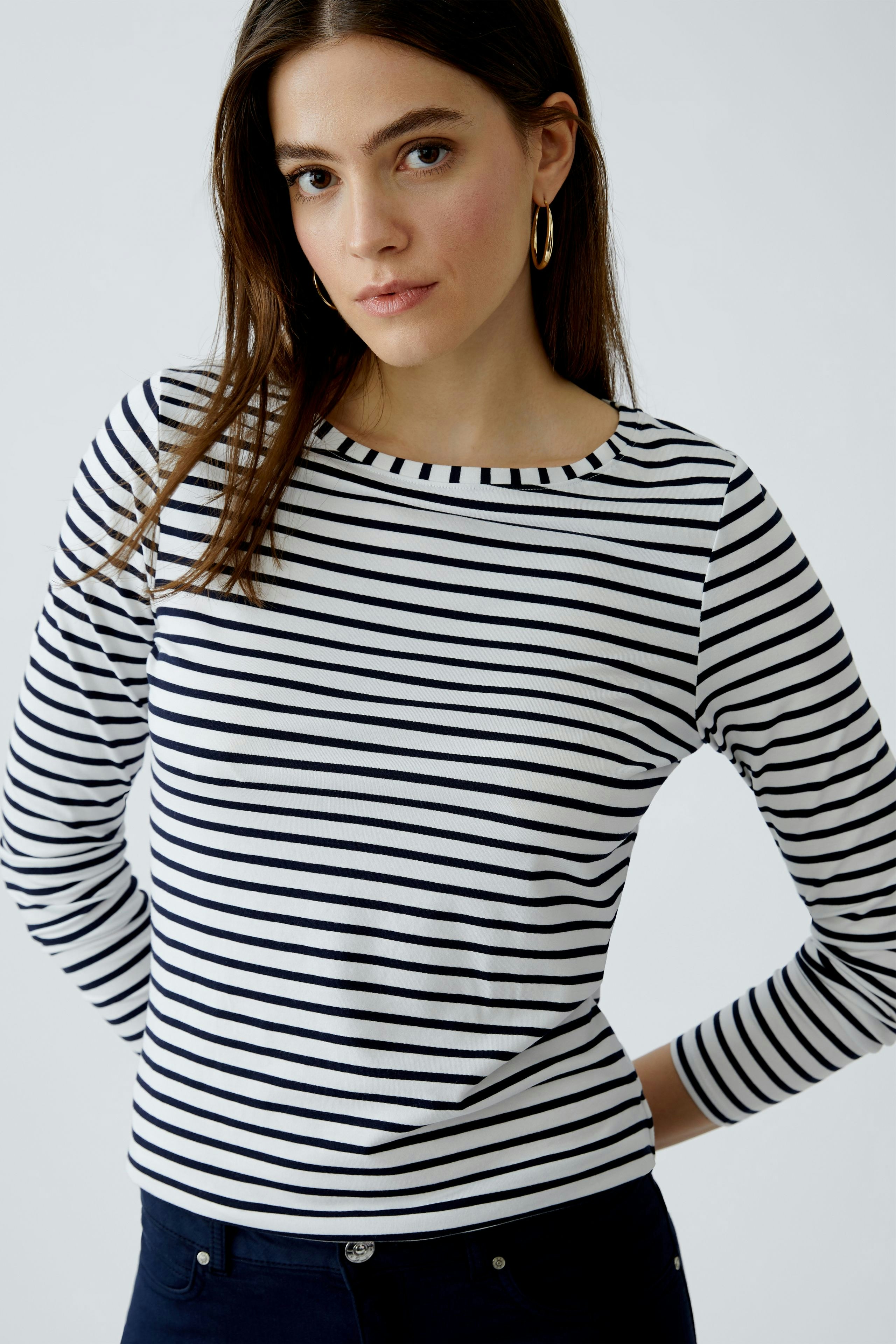 Casual long-sleeve shirt: Woman in a striped pullover with a round neckline, posing confidently.
