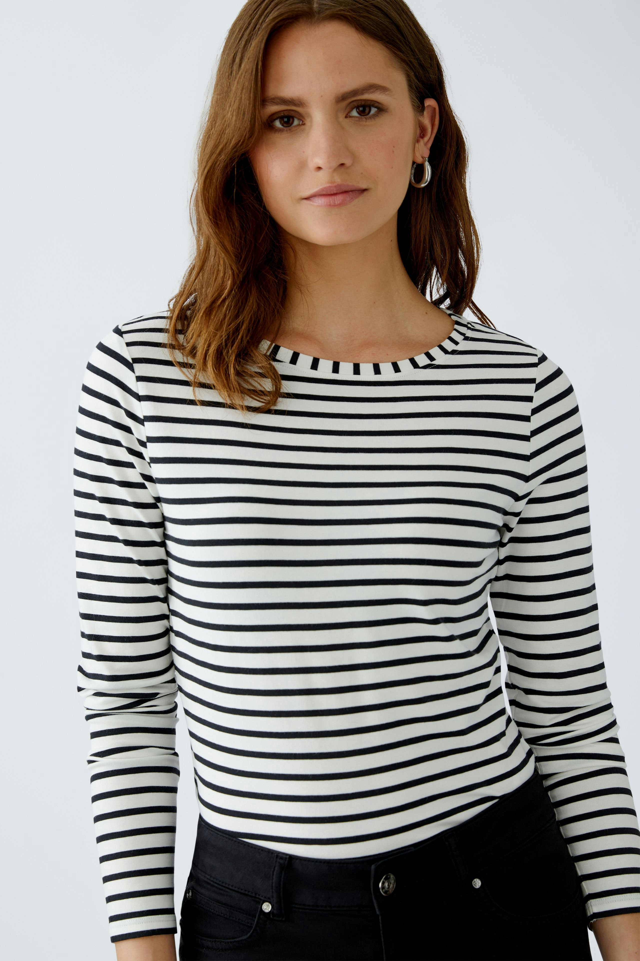 Damen Langarmshirt: Junge Frau in gestreiftem Shirt mit Rundhalsausschnitt und lässigem Look.