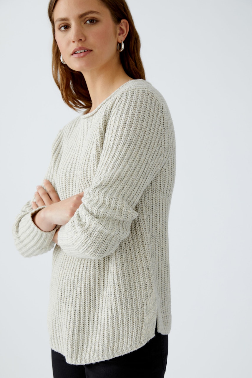 Bequemer Damen-Pullover: Frau in hellem, strukturiertem Strickpullover mit lässigem Schnitt.