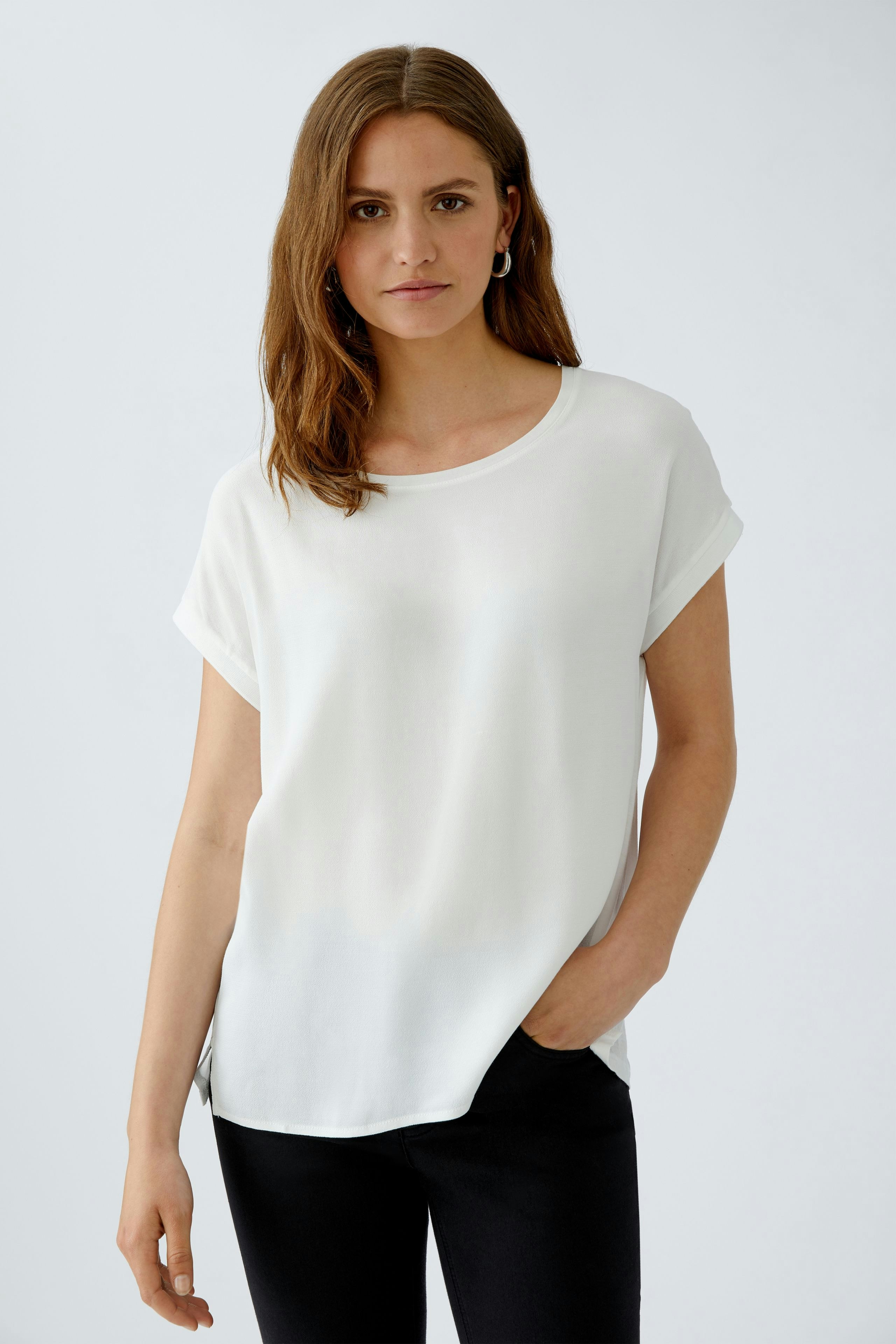 Casual women's blouse shirt: A woman in a white short-sleeve top with a relaxed fit.