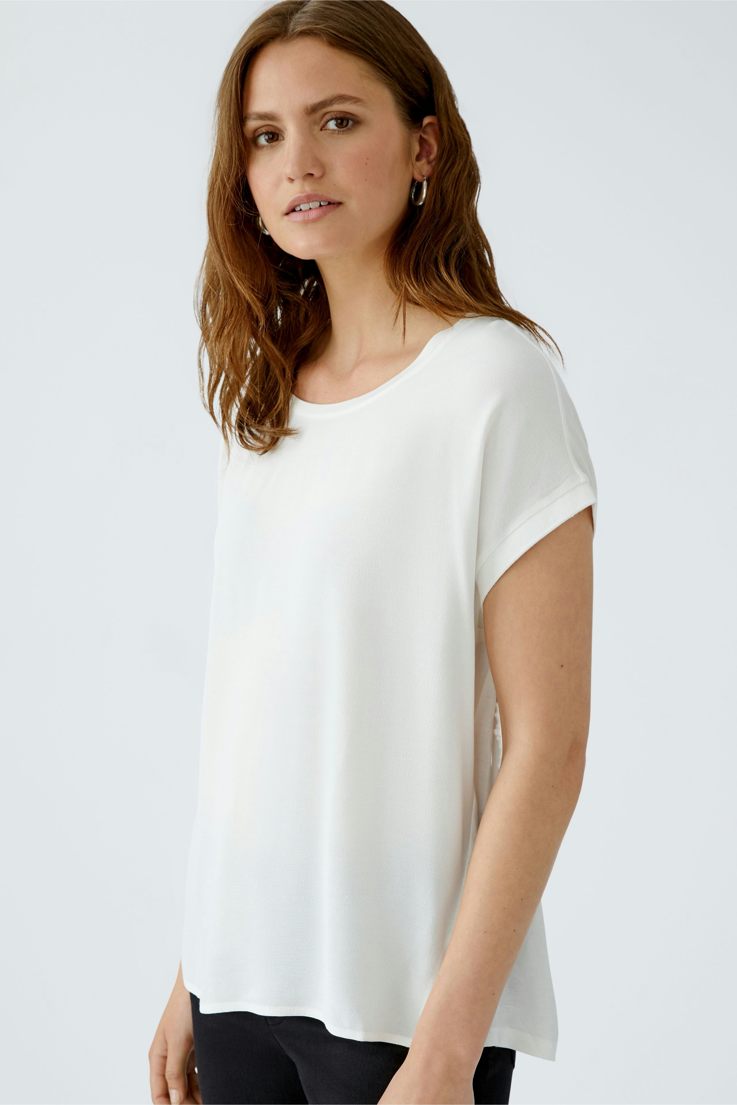 Casual women's blouse shirt: A woman in a white short-sleeve top with a relaxed fit.