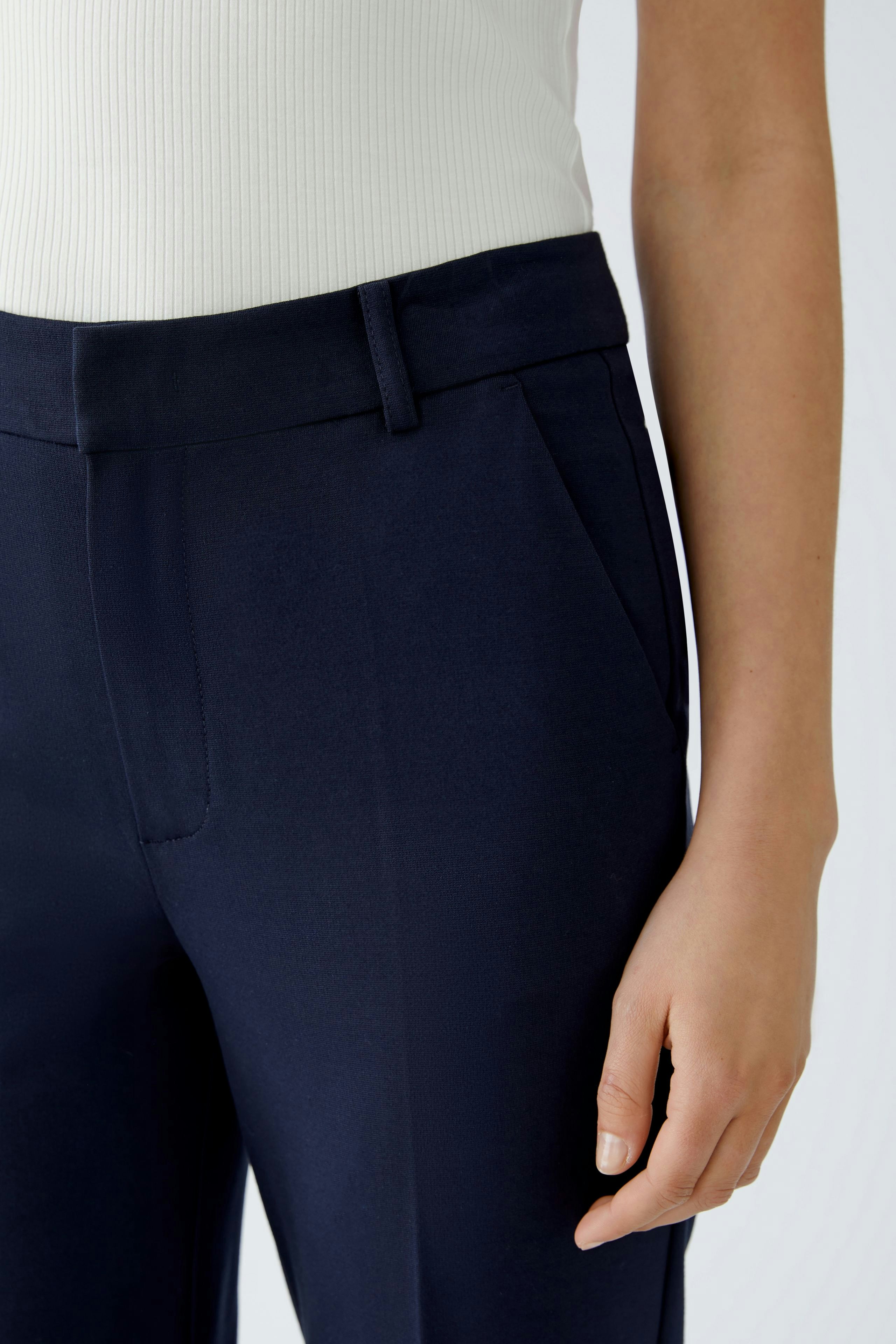 Stylish women's trousers: Close-up of a woman wearing navy pants with a tailored fit.