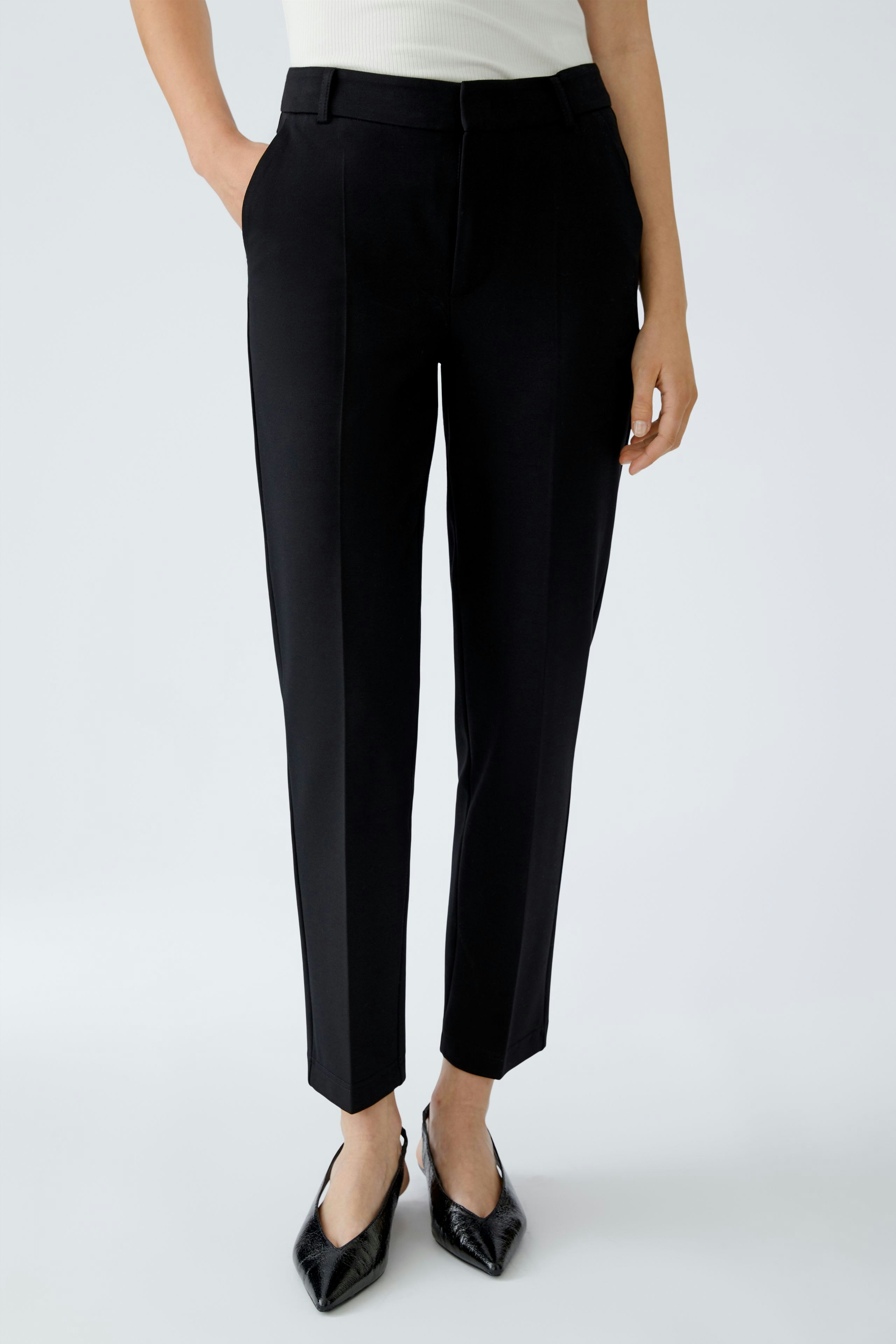 Chic black trousers: Woman in tailored black pants with a sleek fit, paired with stylish heels.