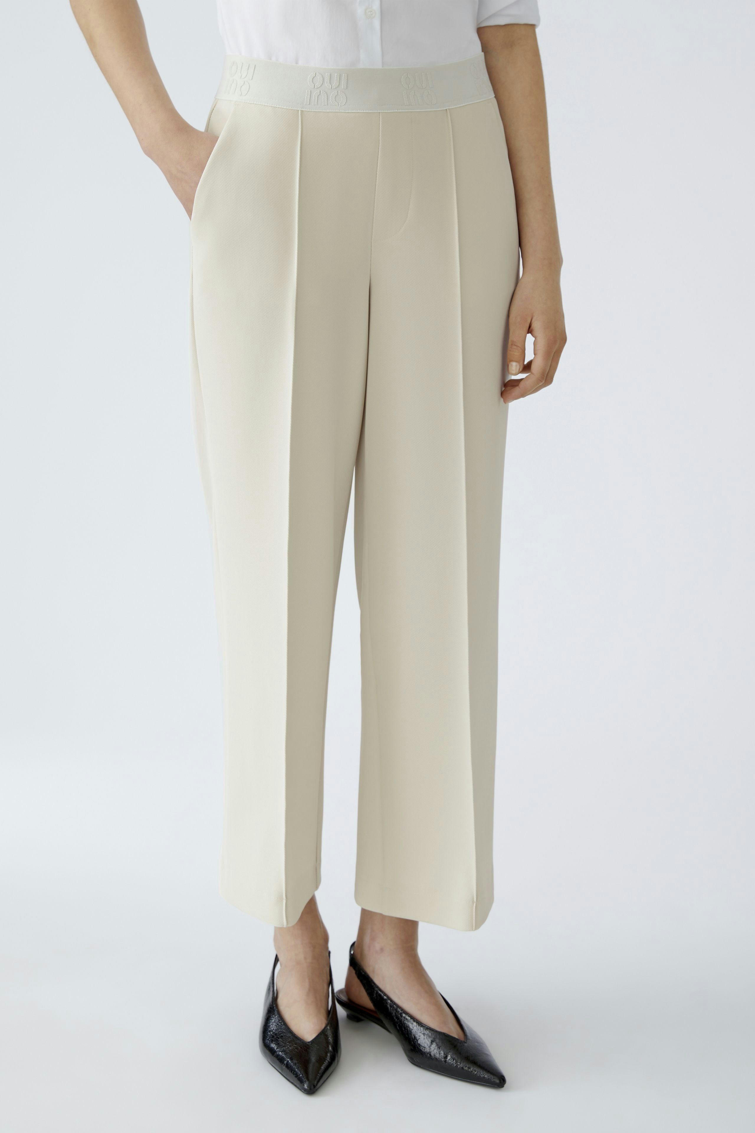 Modern culotte: Woman in cream-colored culottes with a comfortable waistband, styled with chic shoes.