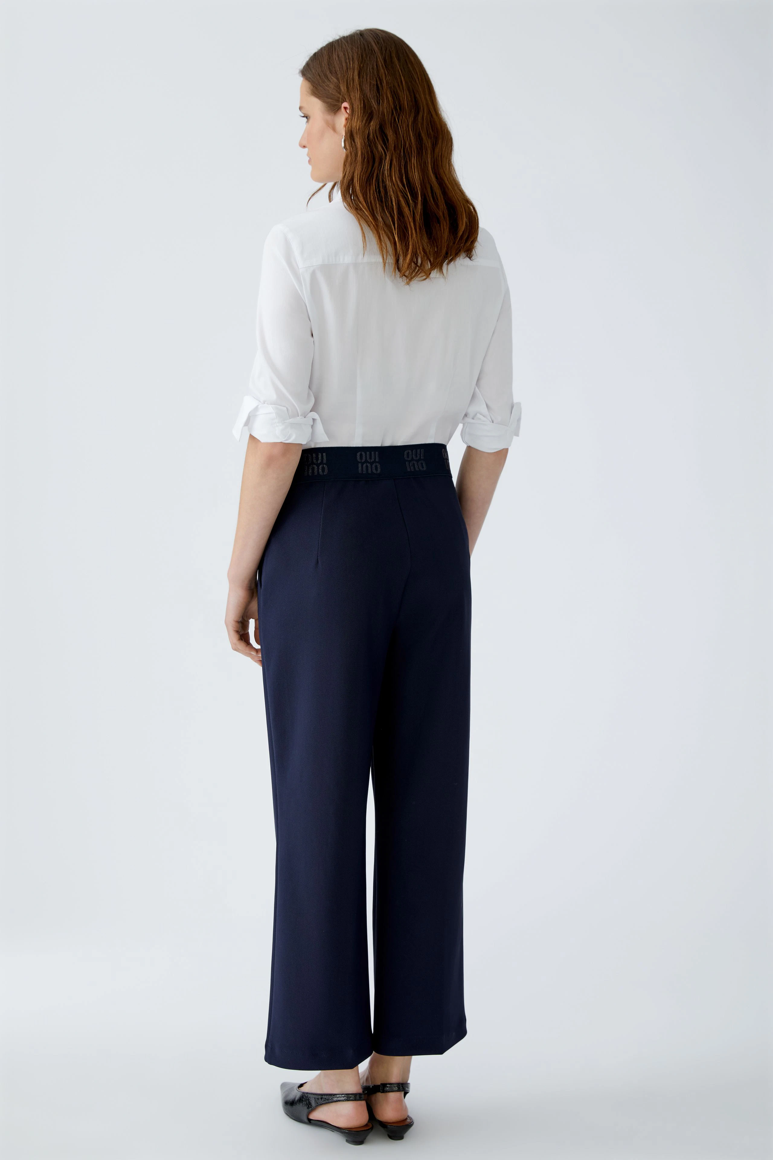 Bequeme Damen-Culotte: Frau in navyfarbener Culotte mit weitem Bein und elastischem Bund von hinten.