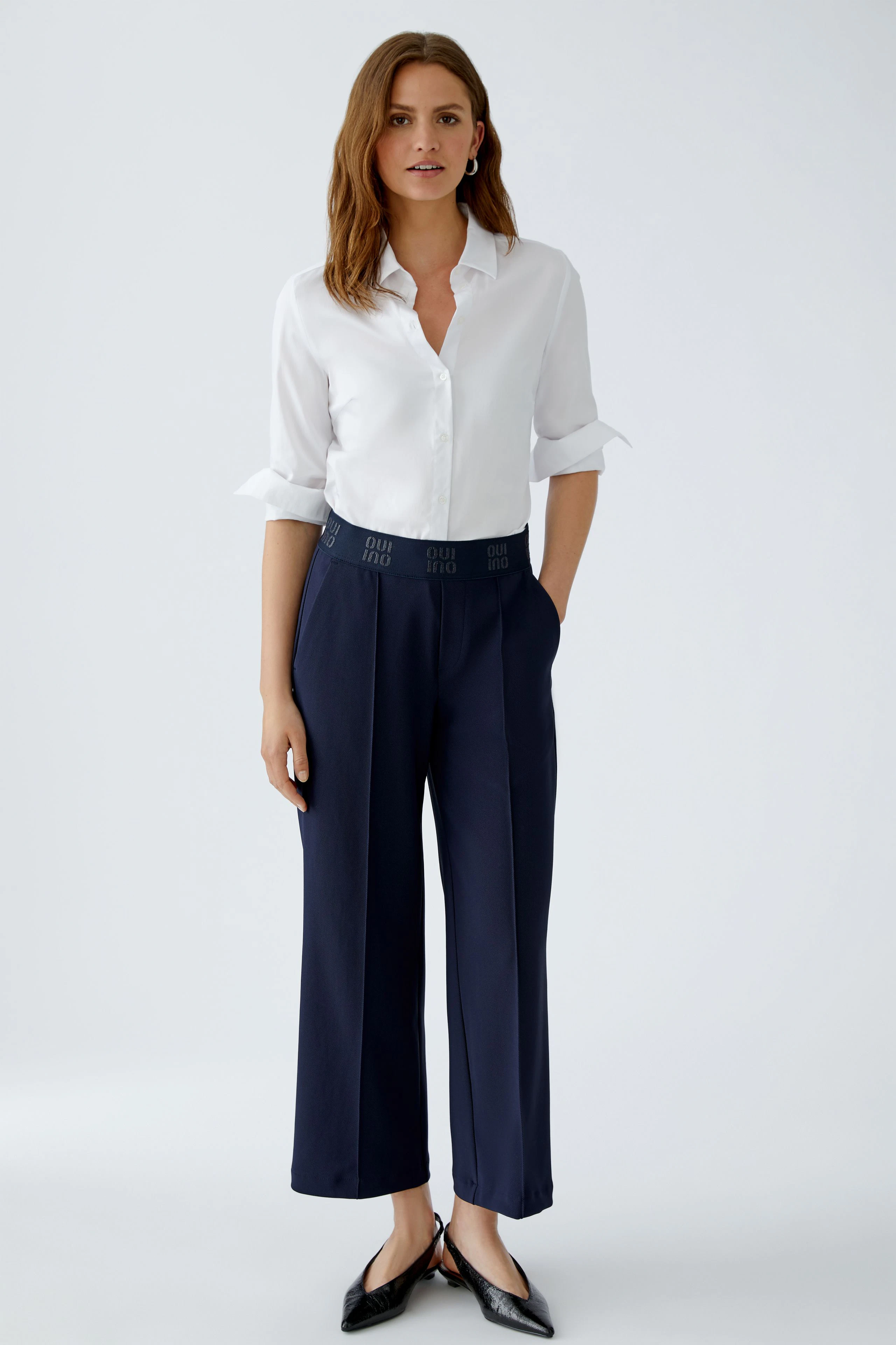 Bequeme Damen-Culotte: Frau in navyfarbener Culotte mit lässigem weißen Hemd und eleganten Schuhen.