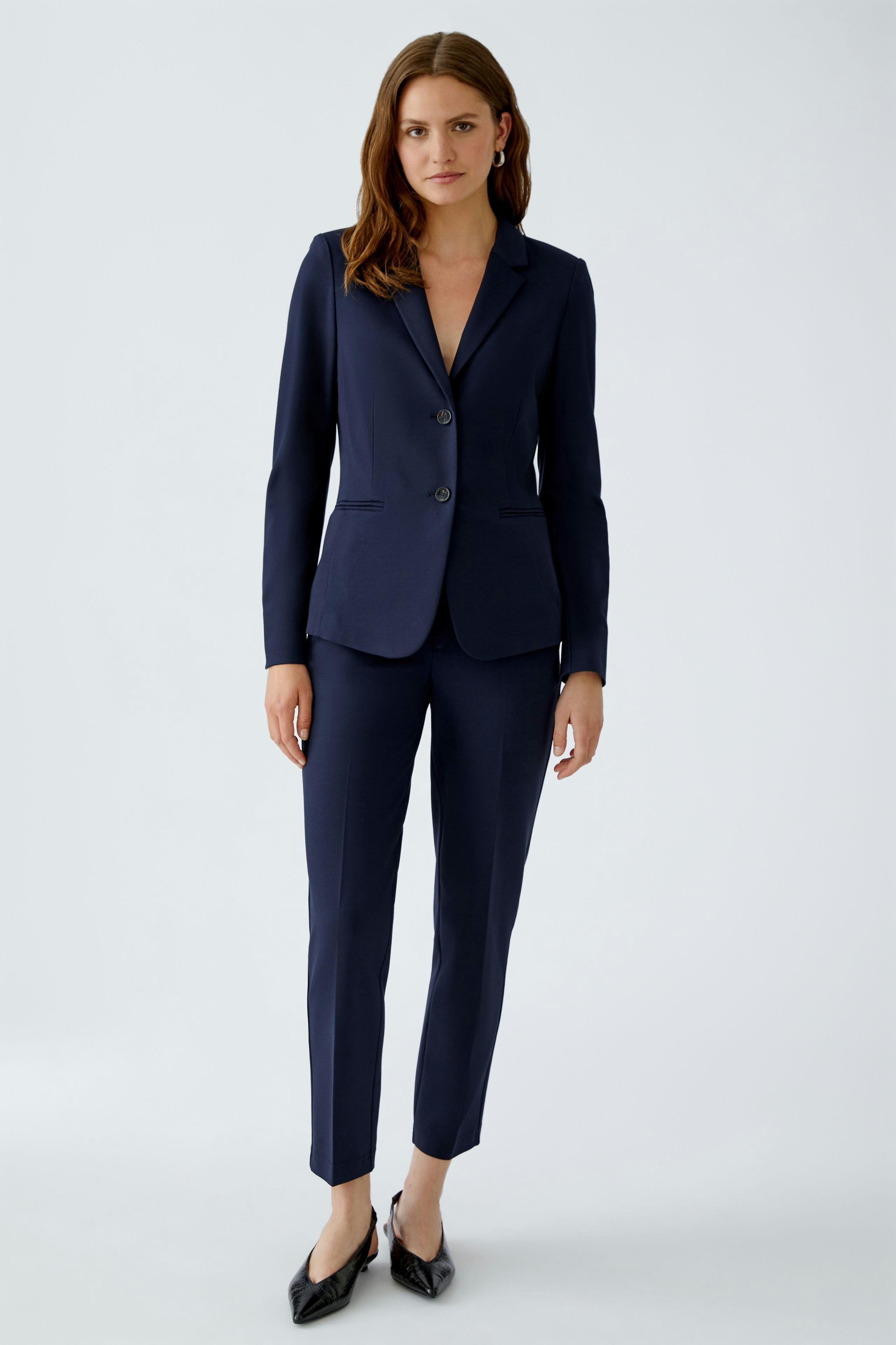 Eleganter Damen-Blazer: Frau in dunkelblauem Blazer mit schmalem Schnitt und Knopfdetails.
