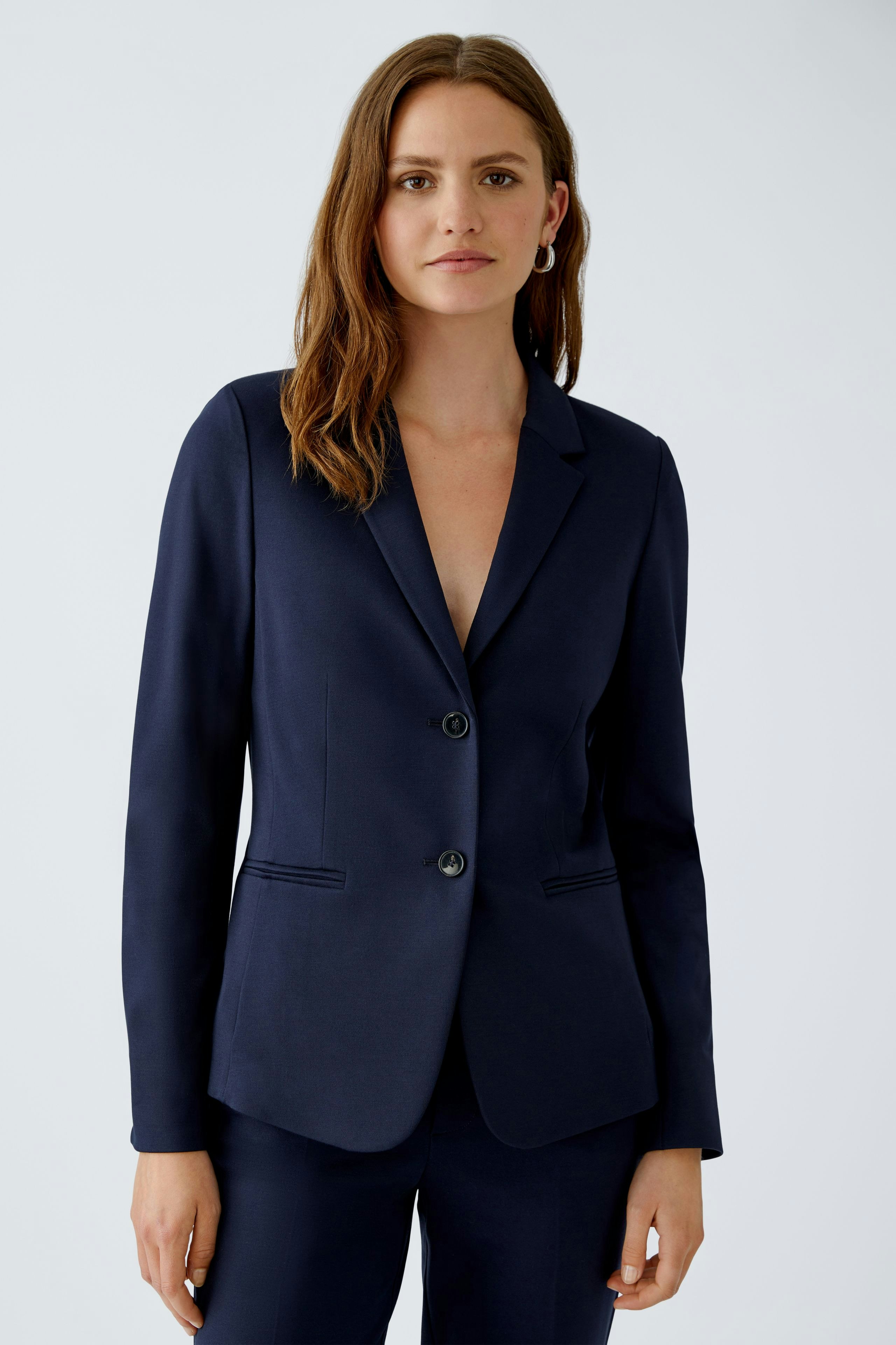 Eleganter Damen-Blazer: Frau in dunkelblauem Blazer mit zwei Knöpfen und schmalem Schnitt.