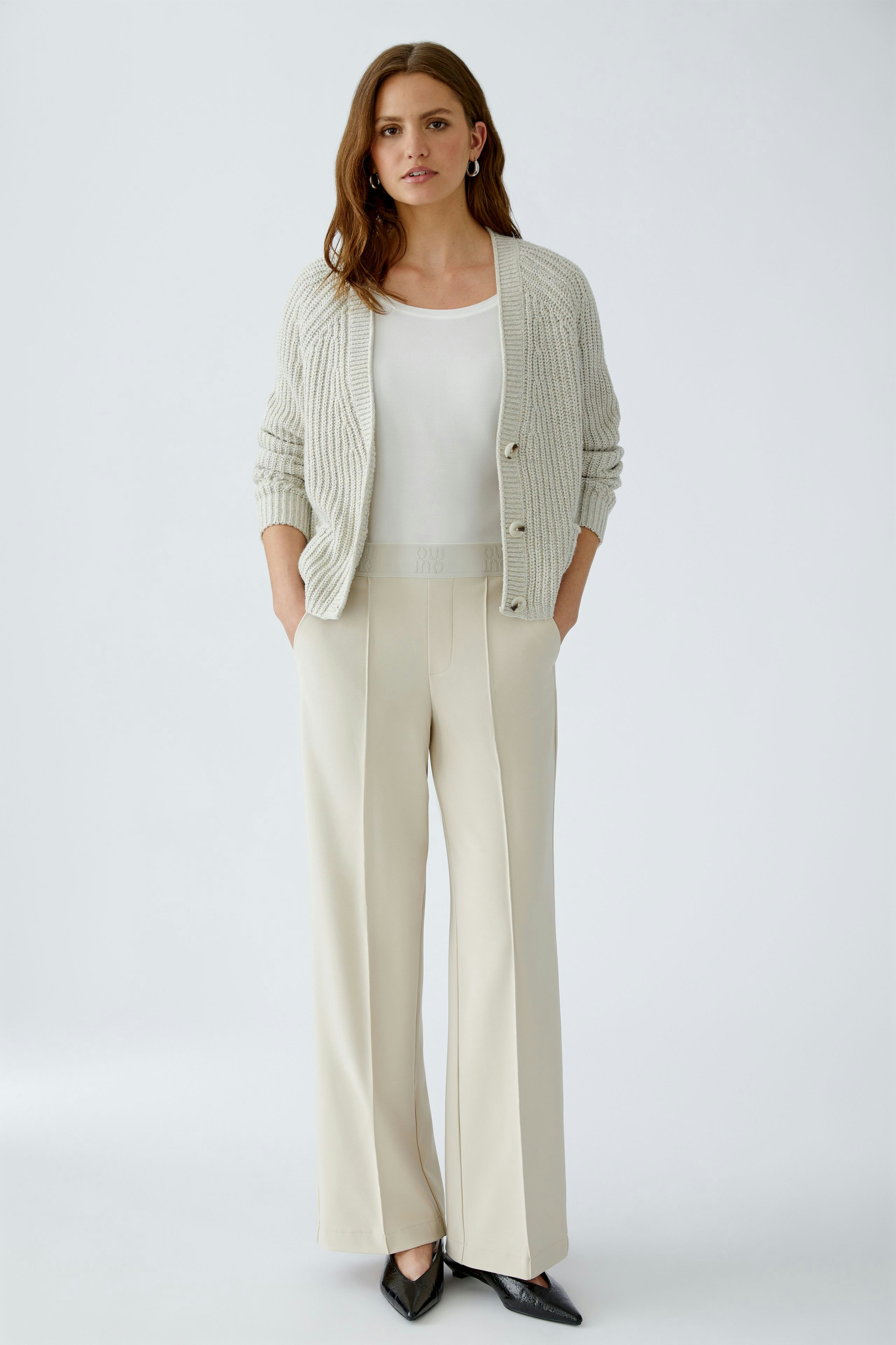 Casual women's trousers: A woman in light beige trousers with a relaxed fit and side pockets.
