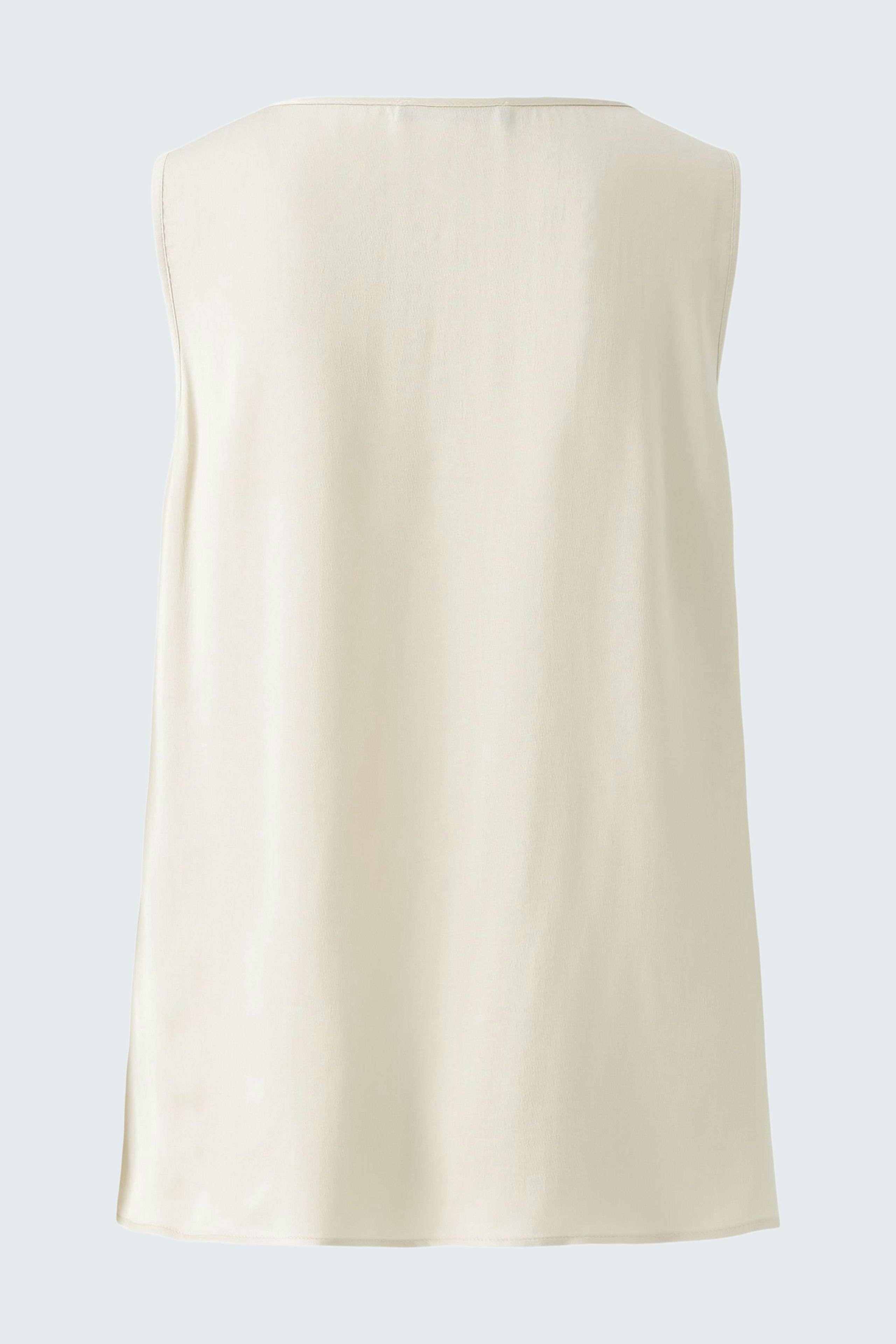Casual women's top: A woman in a light cream sleeveless top, perfect for warm days.