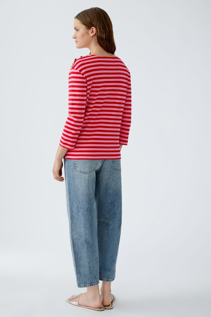 Casual women's long-sleeve shirt: A woman in a red and white striped pullover with relaxed fit.