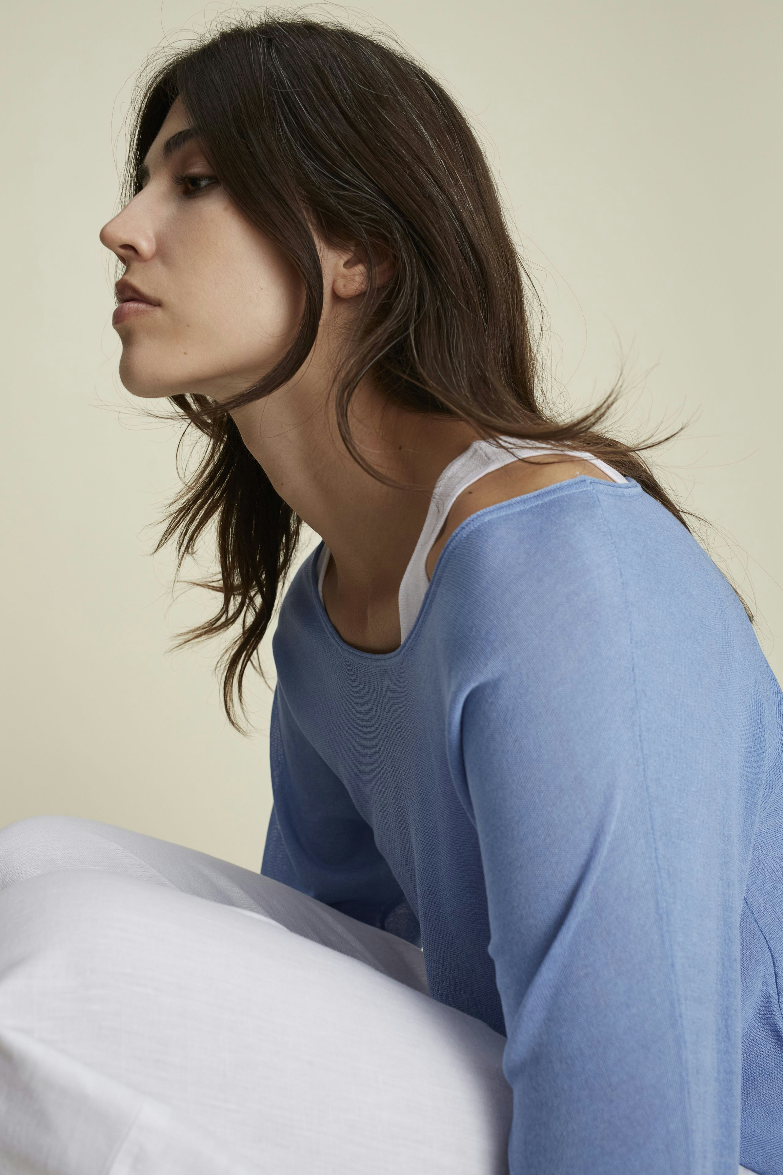 Lässiger Damen-Pullover: Frau in blauem Pullover mit lockerer Passform und weißen Details.