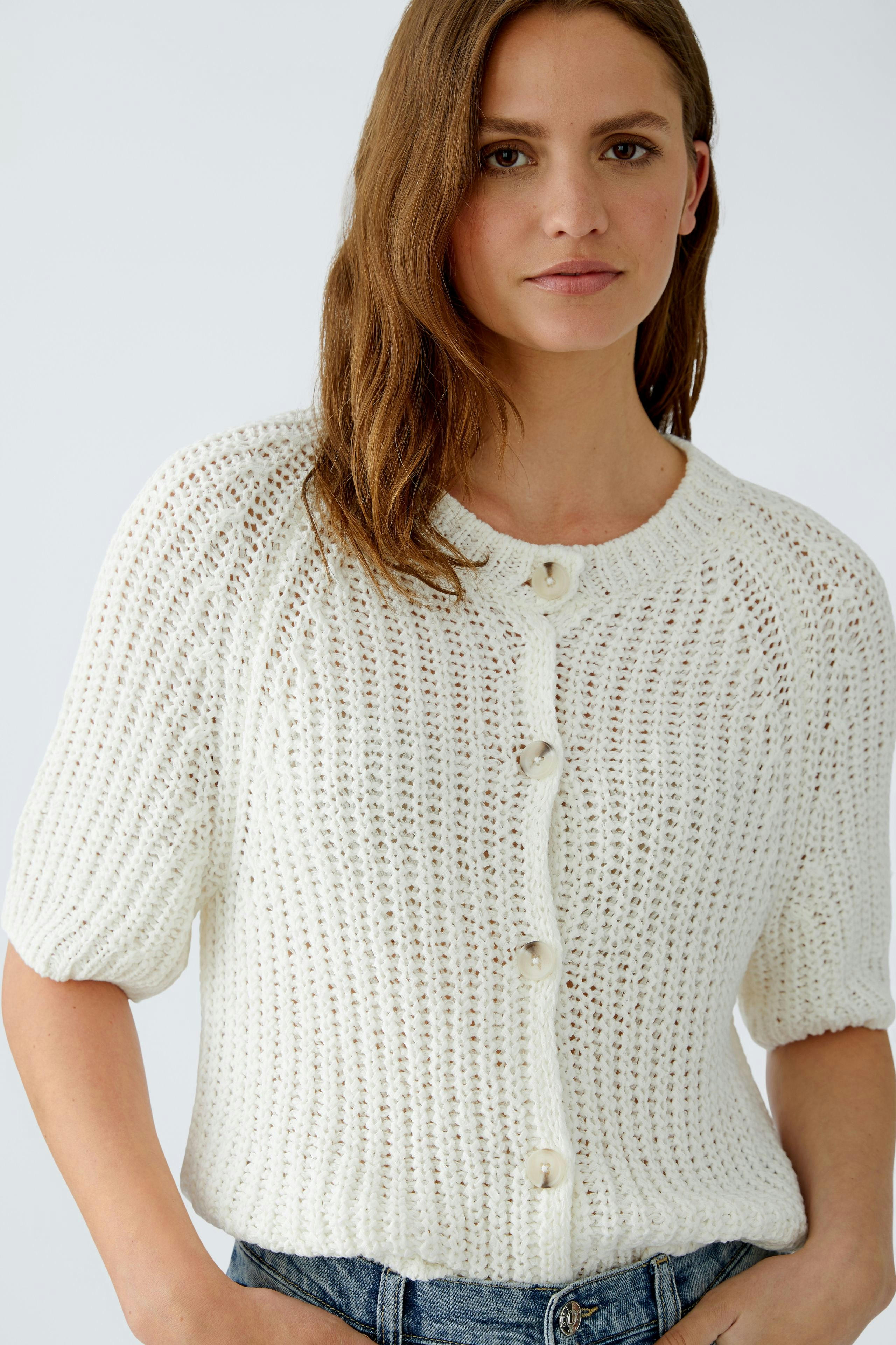 Casual women's cardigan: A woman in a white knitted cardigan with buttons and short sleeves.