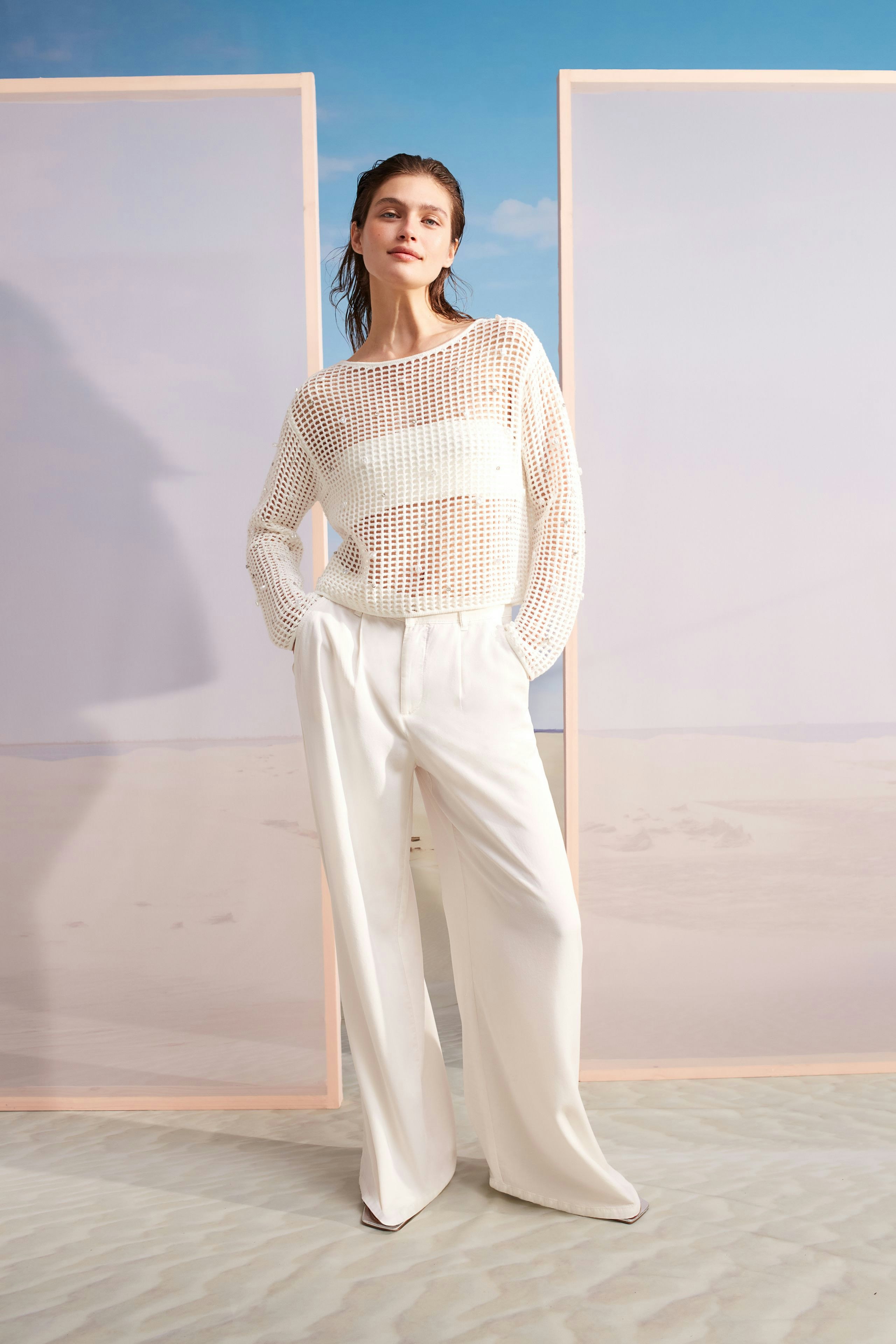 Moderne Bundfaltenhose: Frau in lässiger, heller Hose mit weitem Schnitt und atmungsaktivem Oberteil.