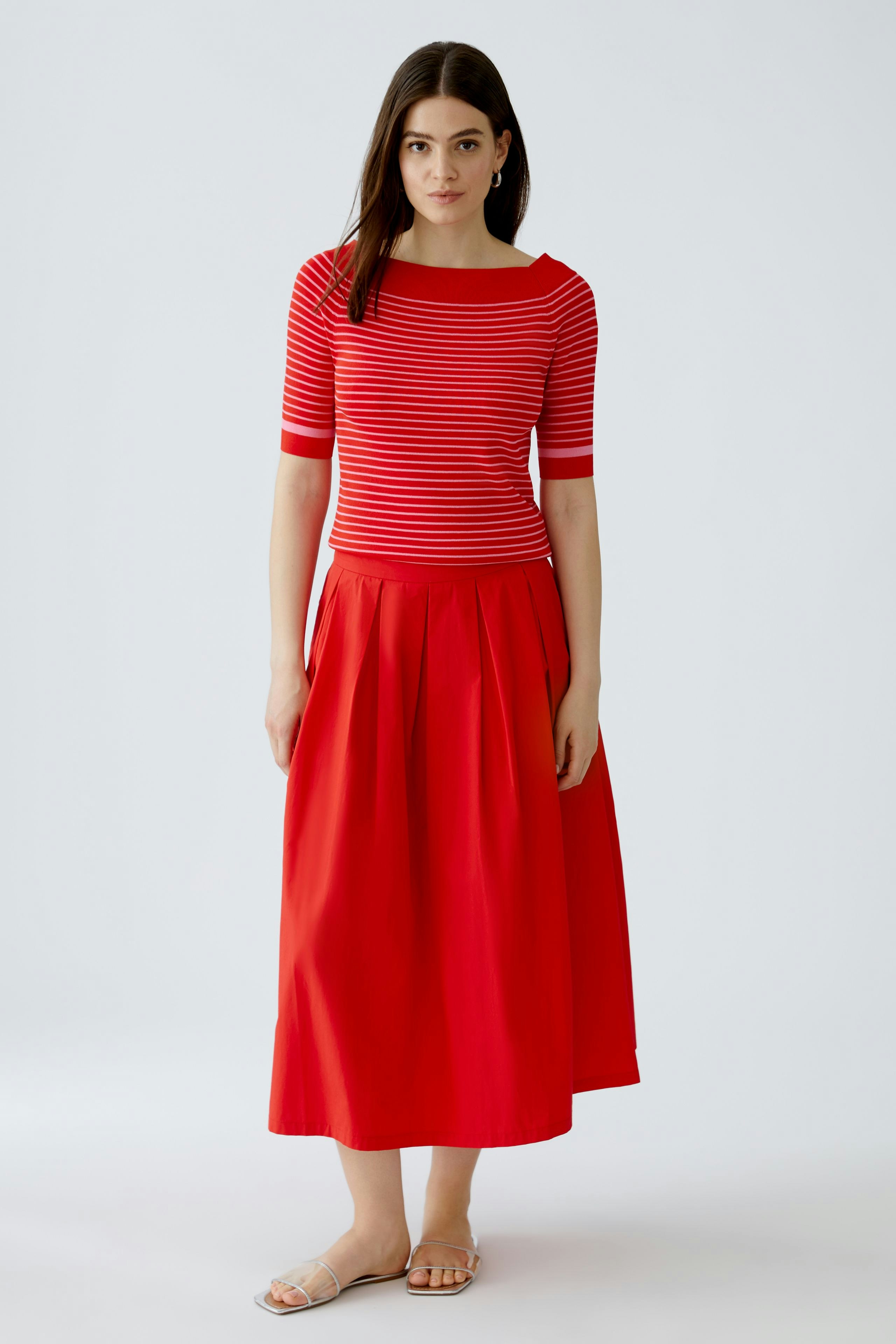 Damen-Pullover: Frau in rot-gestreiftem Pullover mit weitem Rundhalsausschnitt und lässigem Rock.