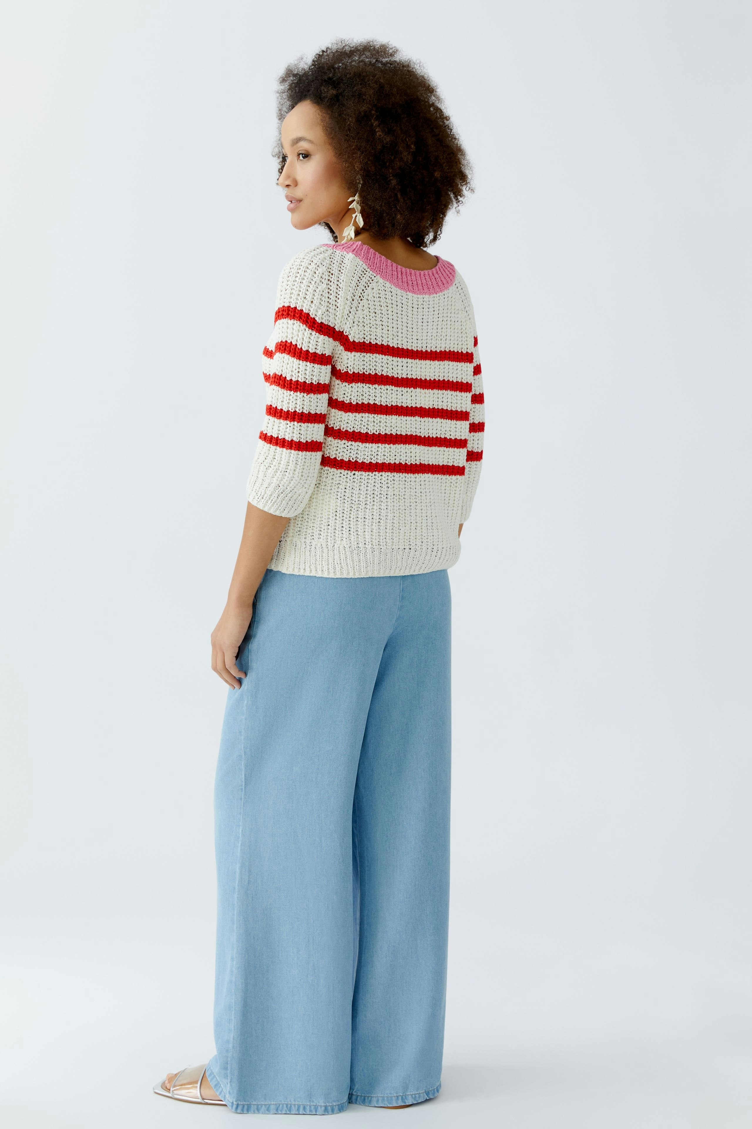 Casual women's pullover: Young woman in a striped knit pullover with wide sleeves and relaxed fit.