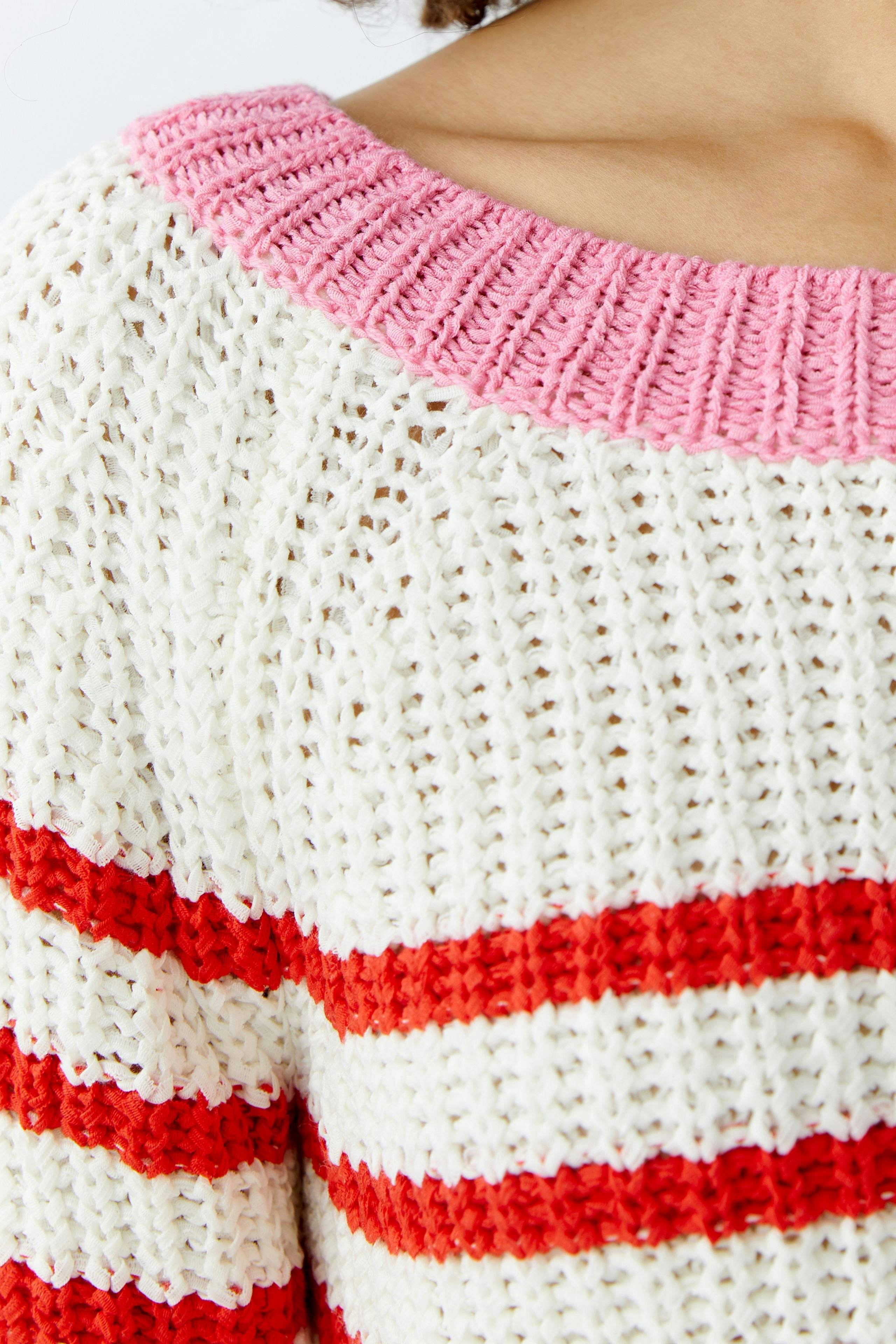 Casual women's pullover: Close-up of a relaxed knit pullover with pink and red stripes.