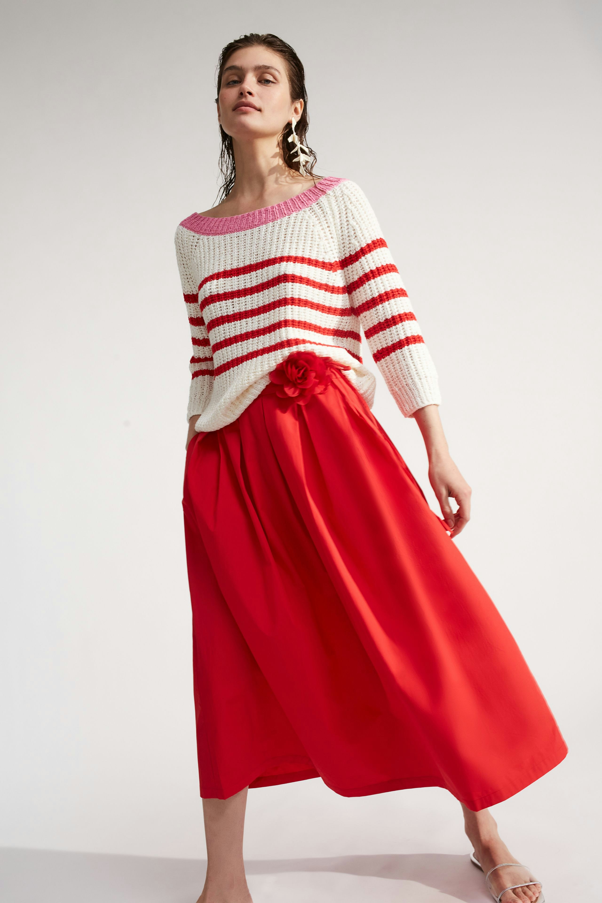 Casual women's pullover: Young woman in a striped knit pullover with a relaxed fit.