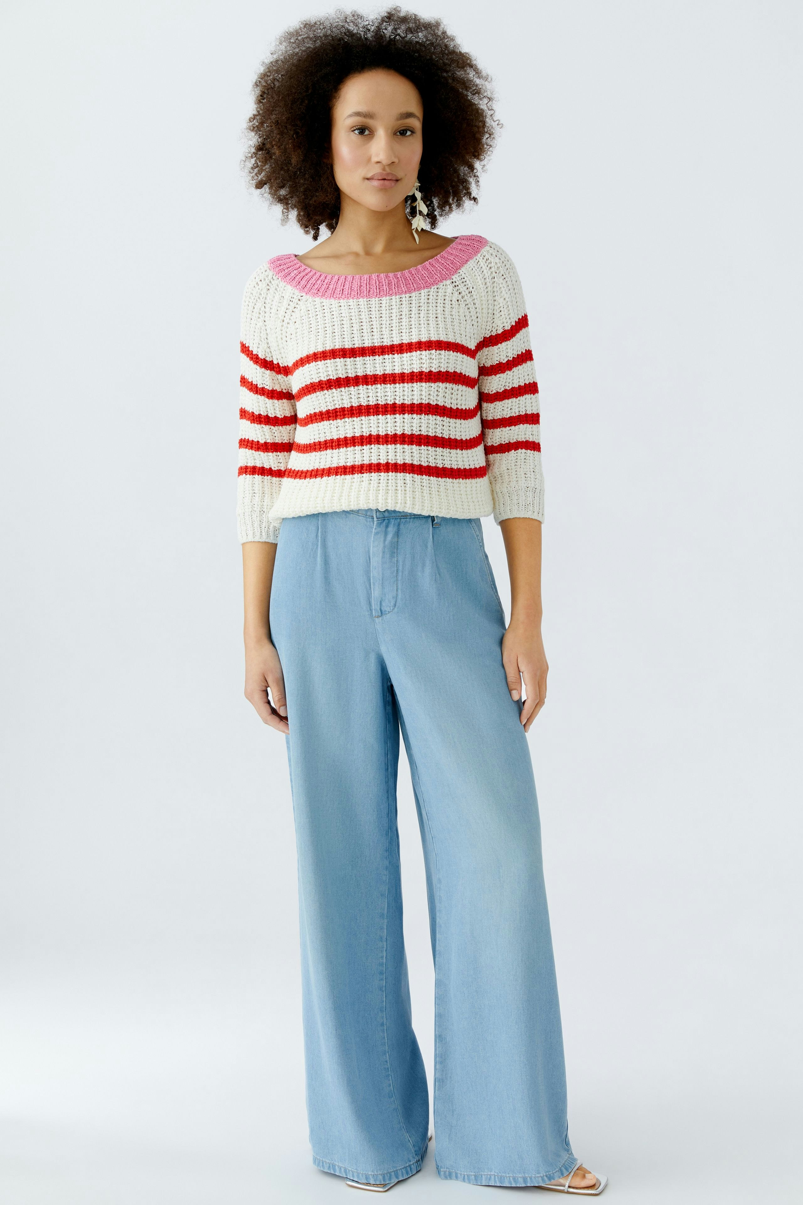 Casual women's pullover: Young woman in a striped knit pullover with wide-leg jeans.