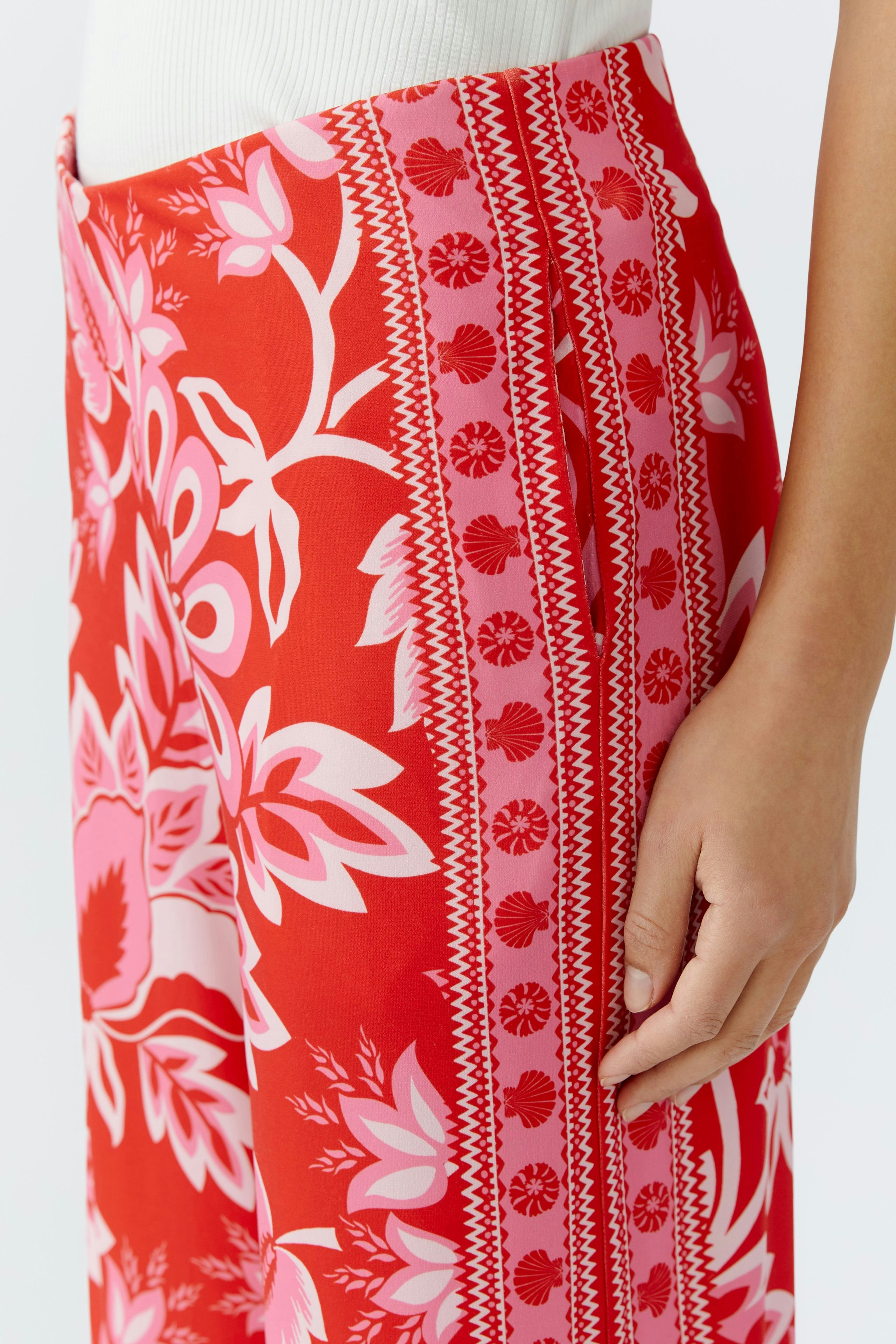 Vibrant women's trousers with floral patterns, featuring side pockets and a relaxed fit.