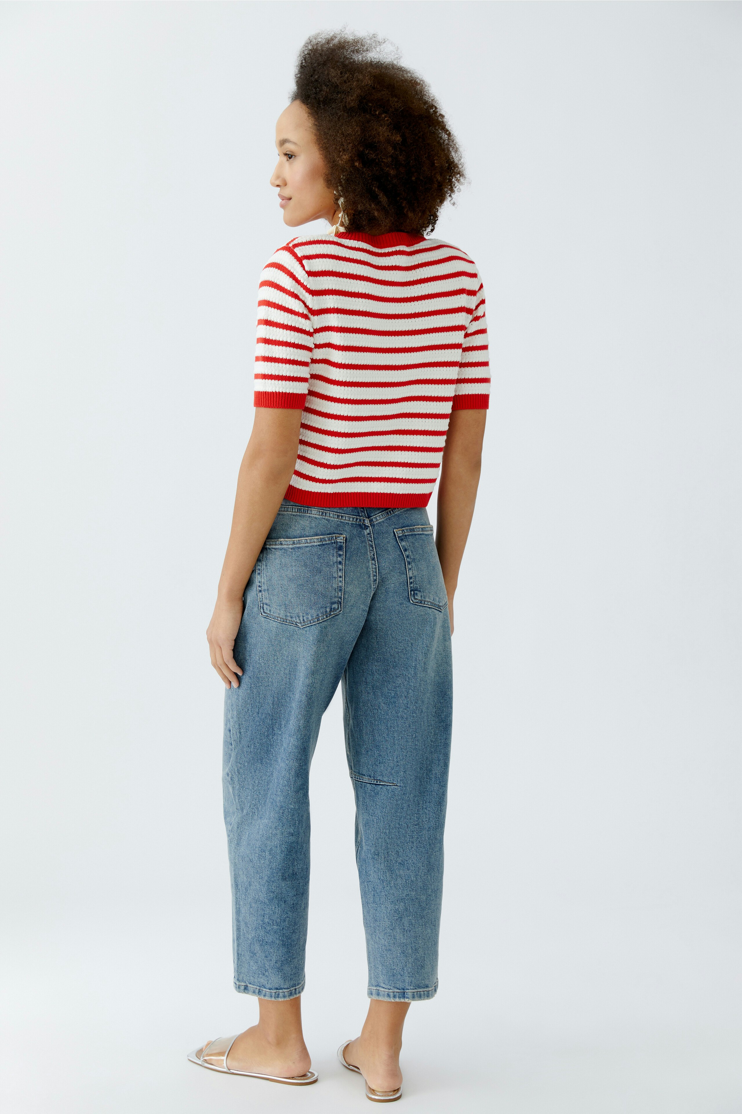 Damen-Strickjacke: Frau mit gestreiftem Oberteil und Jeans, lässig und modern.