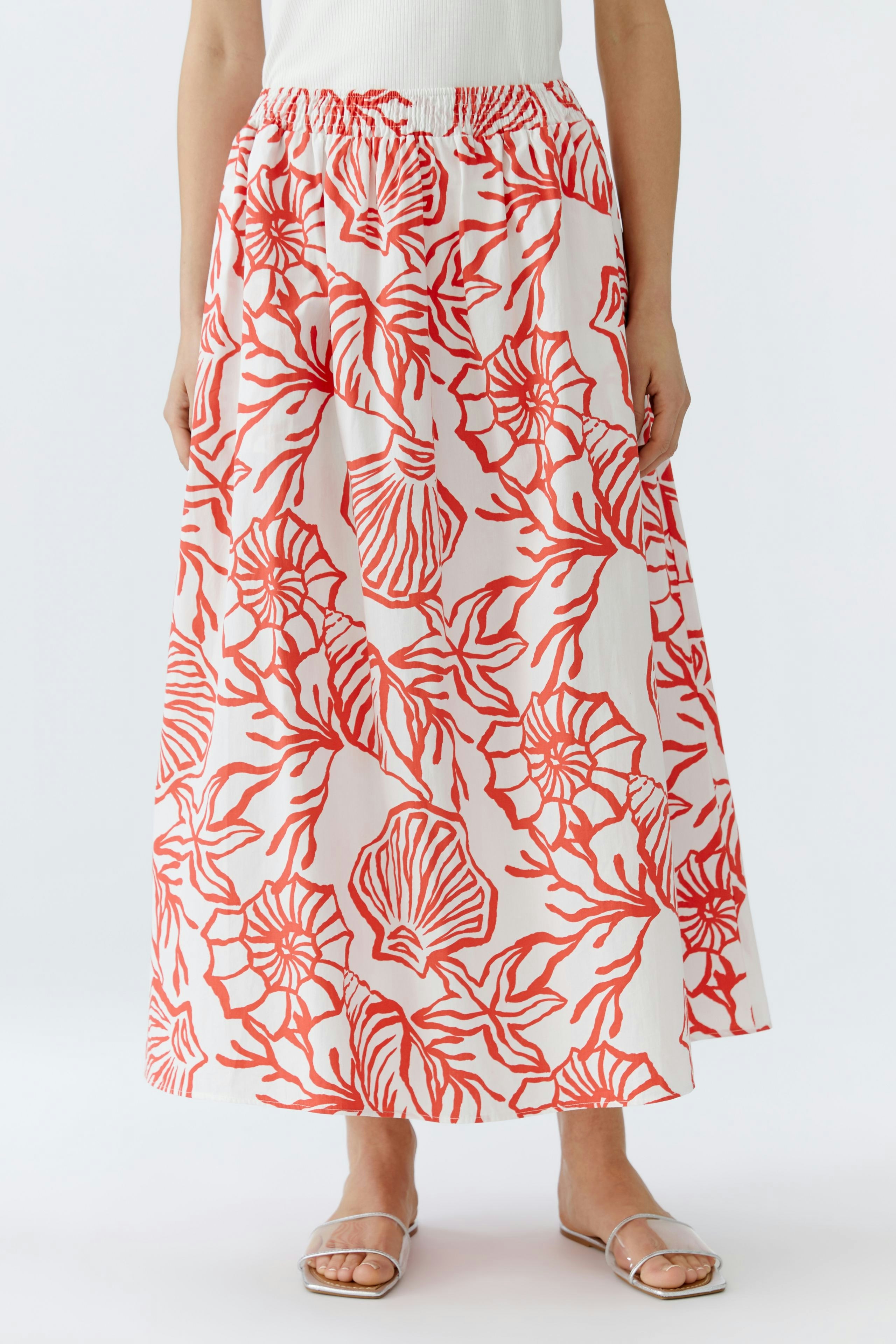 Maxi skirt: Woman in a flowy skirt with a vibrant shell print, perfect for casual summer outings.