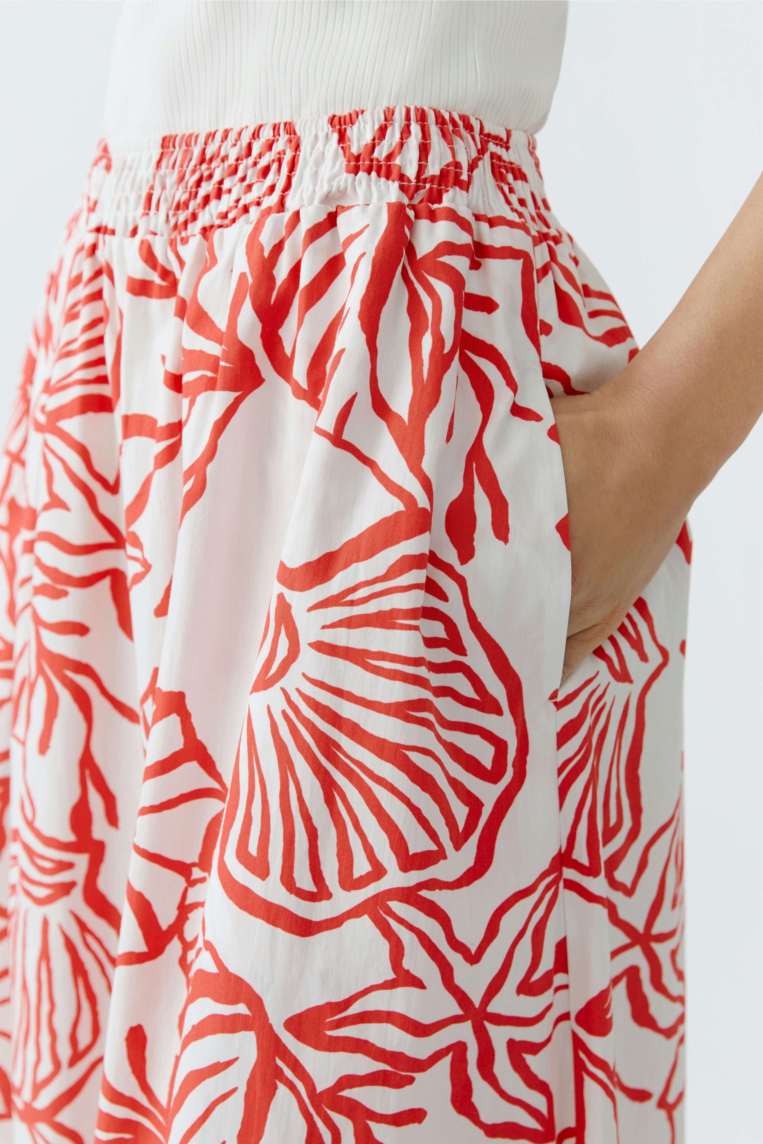 Lightweight maxi skirt with a vibrant red floral pattern, featuring an elastic waistband and pockets.