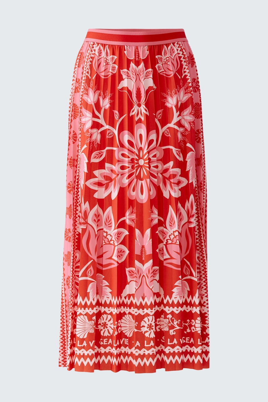 Flowy pleated skirt: A woman in a vibrant red skirt with floral patterns, perfect for casual outings.