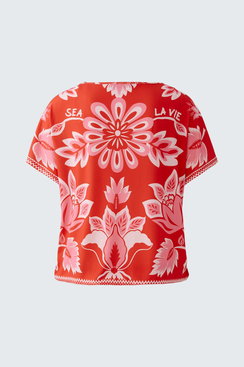 Vibrant women's T-shirt with floral print in red and pink, perfect for casual summer days.