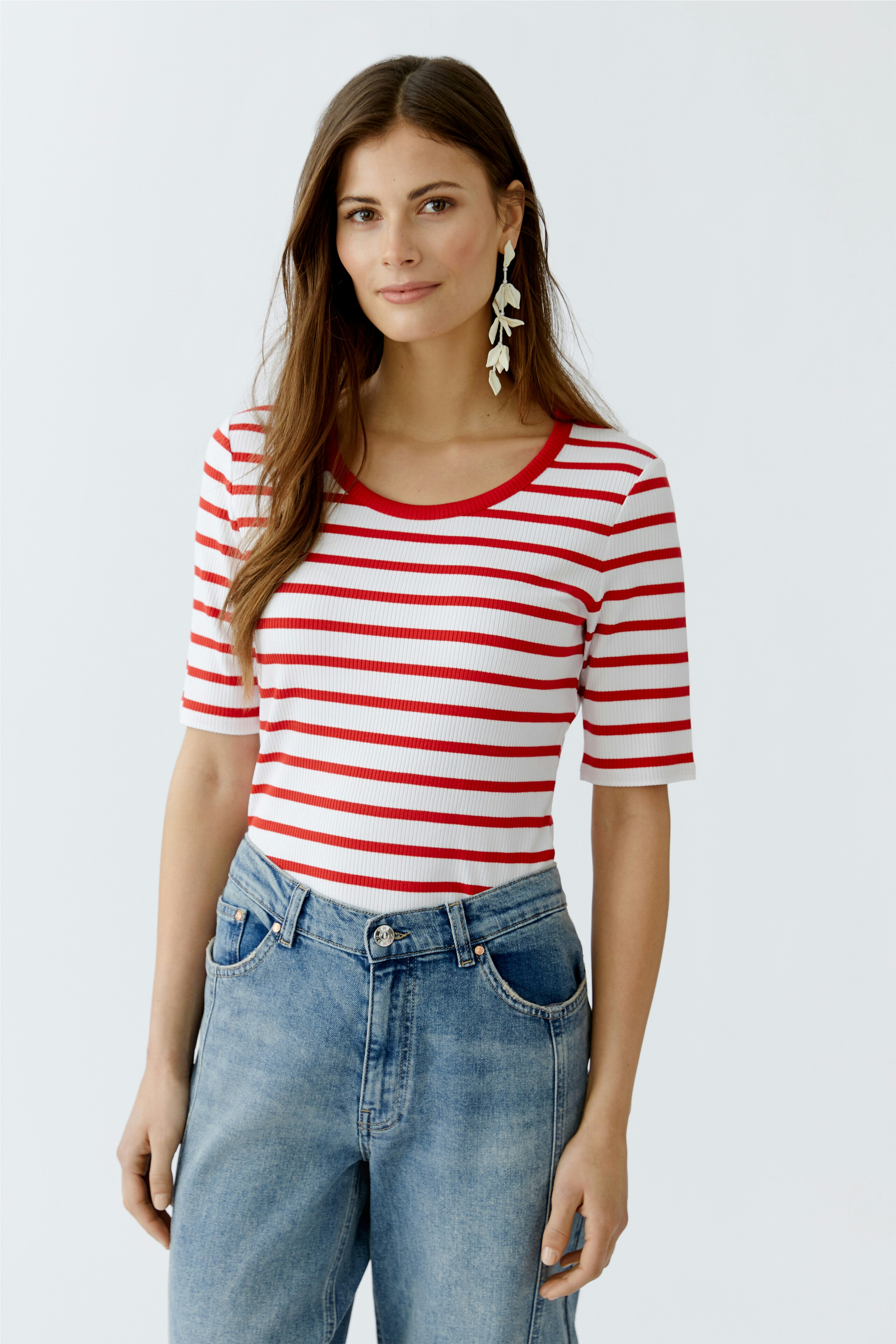 Casual women's T-shirt: Young woman in a red and white striped tee with a round neckline and relaxed fit.