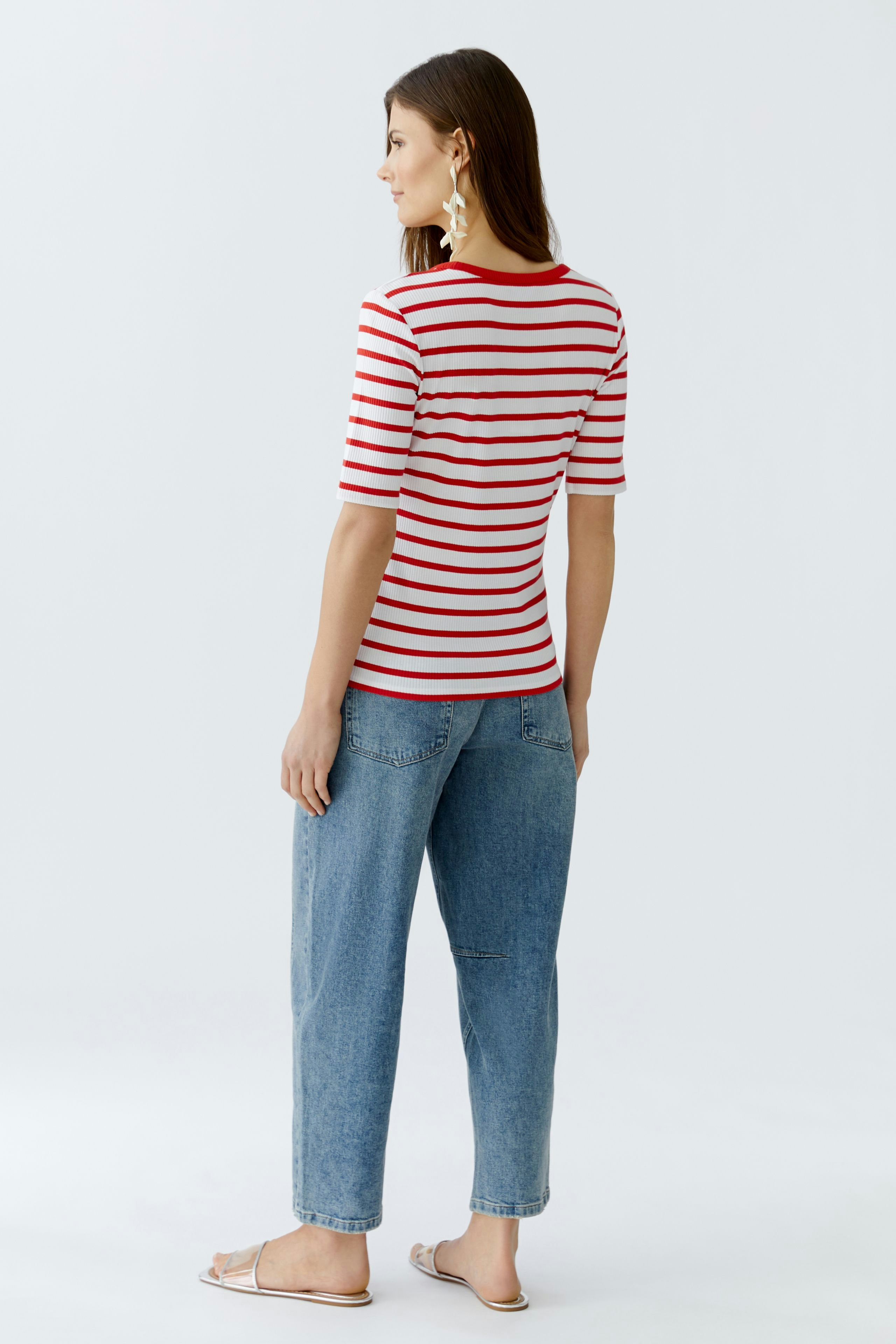 Casual women's T-shirt: A woman in a red and white striped tee paired with relaxed jeans.