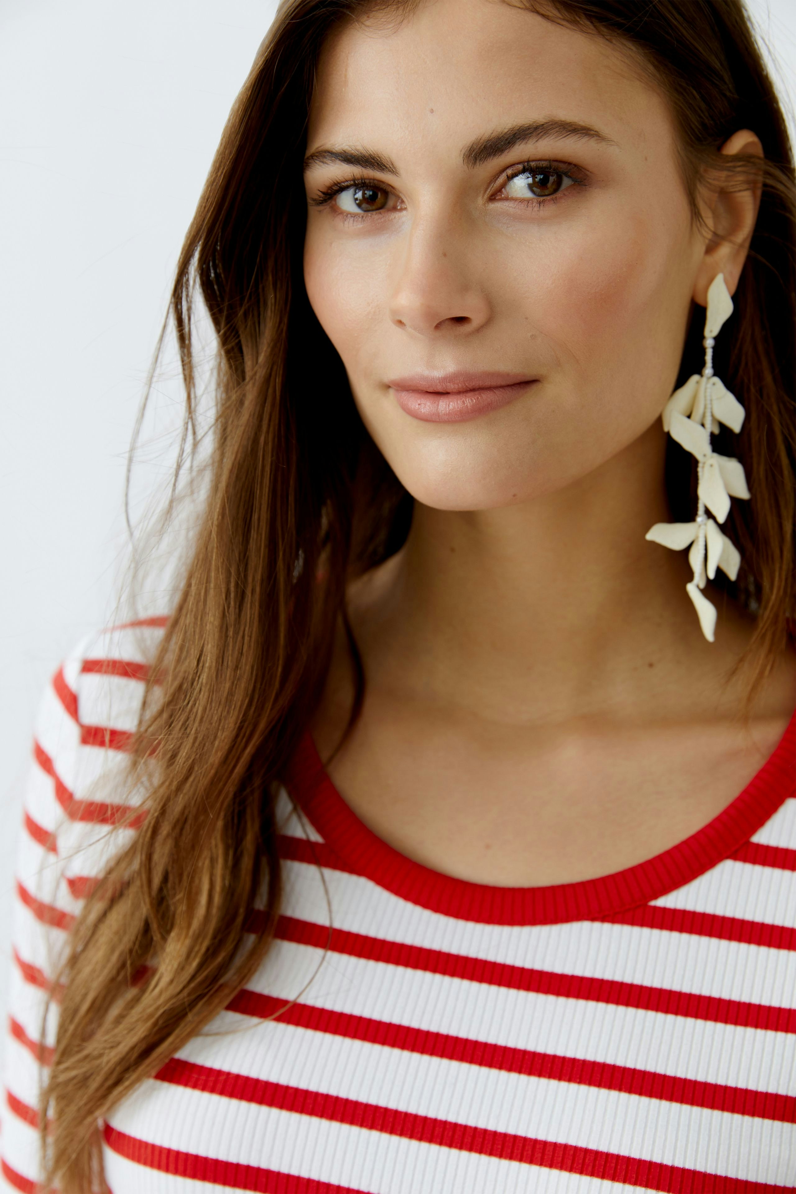 Casual women's T-shirt: Young woman in a red and white striped tee with a round neckline.