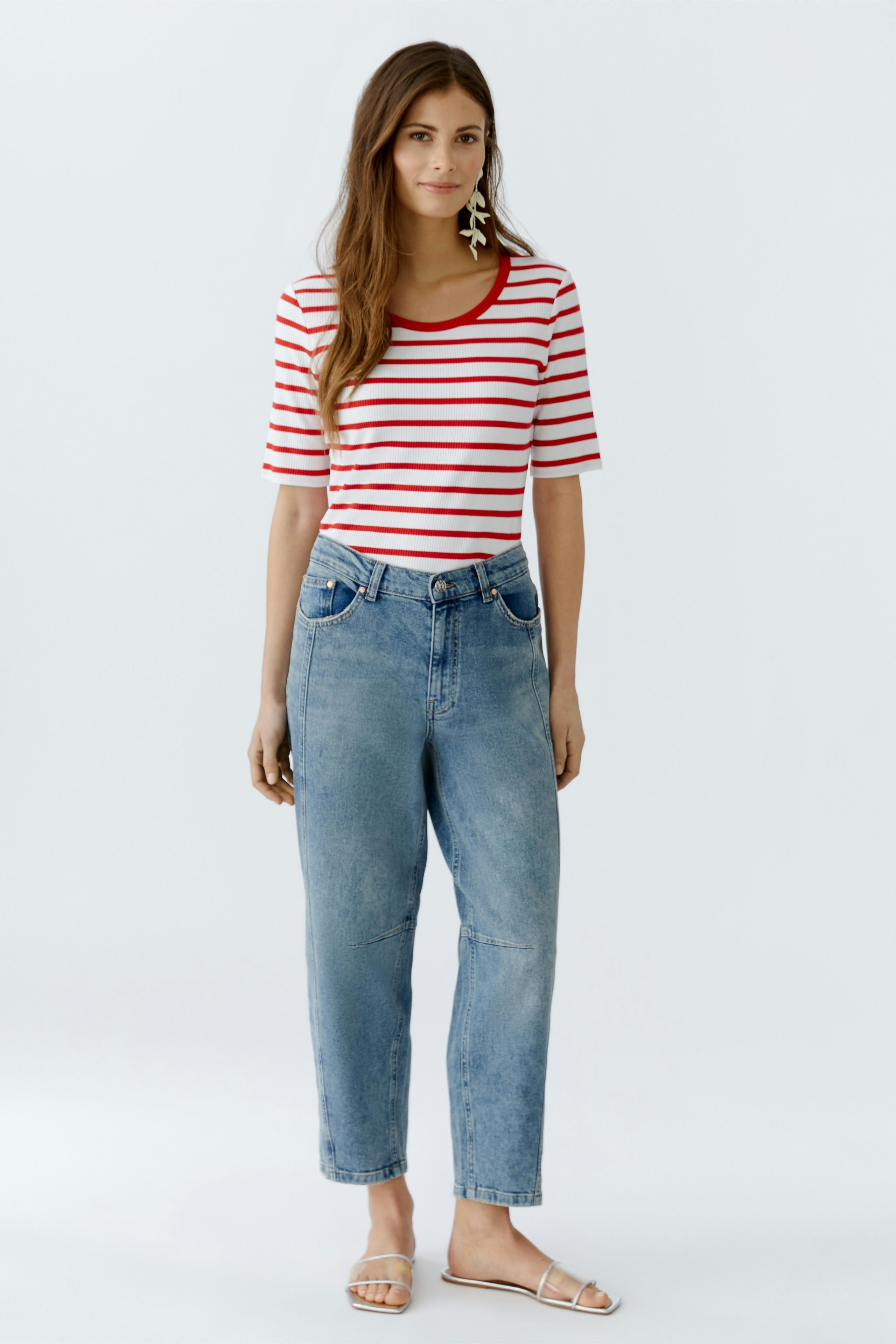 Casual women's T-shirt: Young woman in a red and white striped tee with relaxed fit.