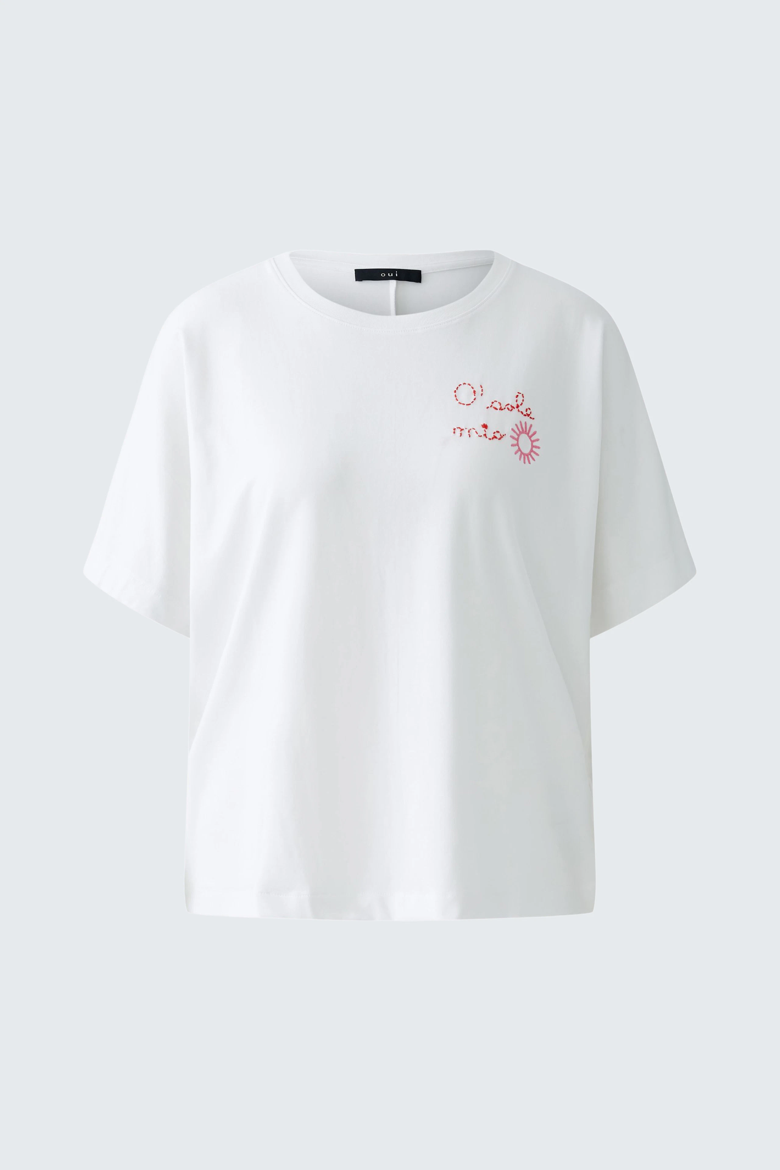 Casual women's t-shirt: A woman in a white tee with pink embroidery, perfect for everyday wear.