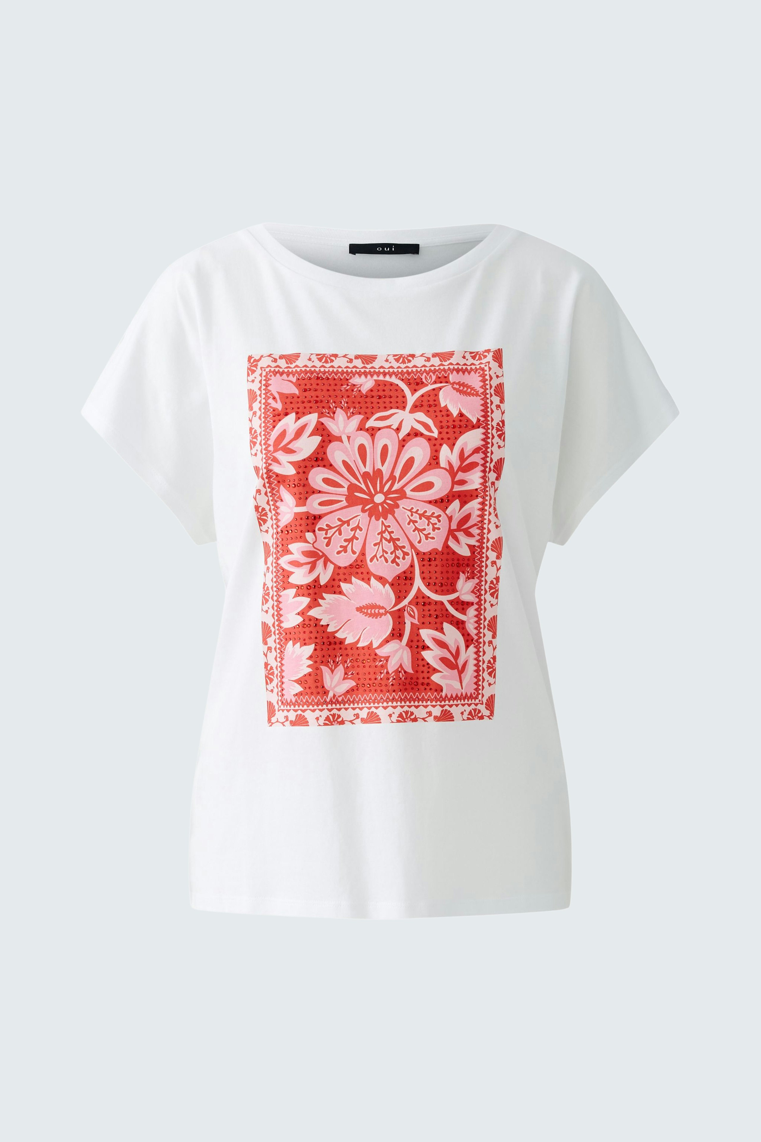 Casual women's t-shirt: A woman in a white tee with a red floral print, perfect for everyday wear.