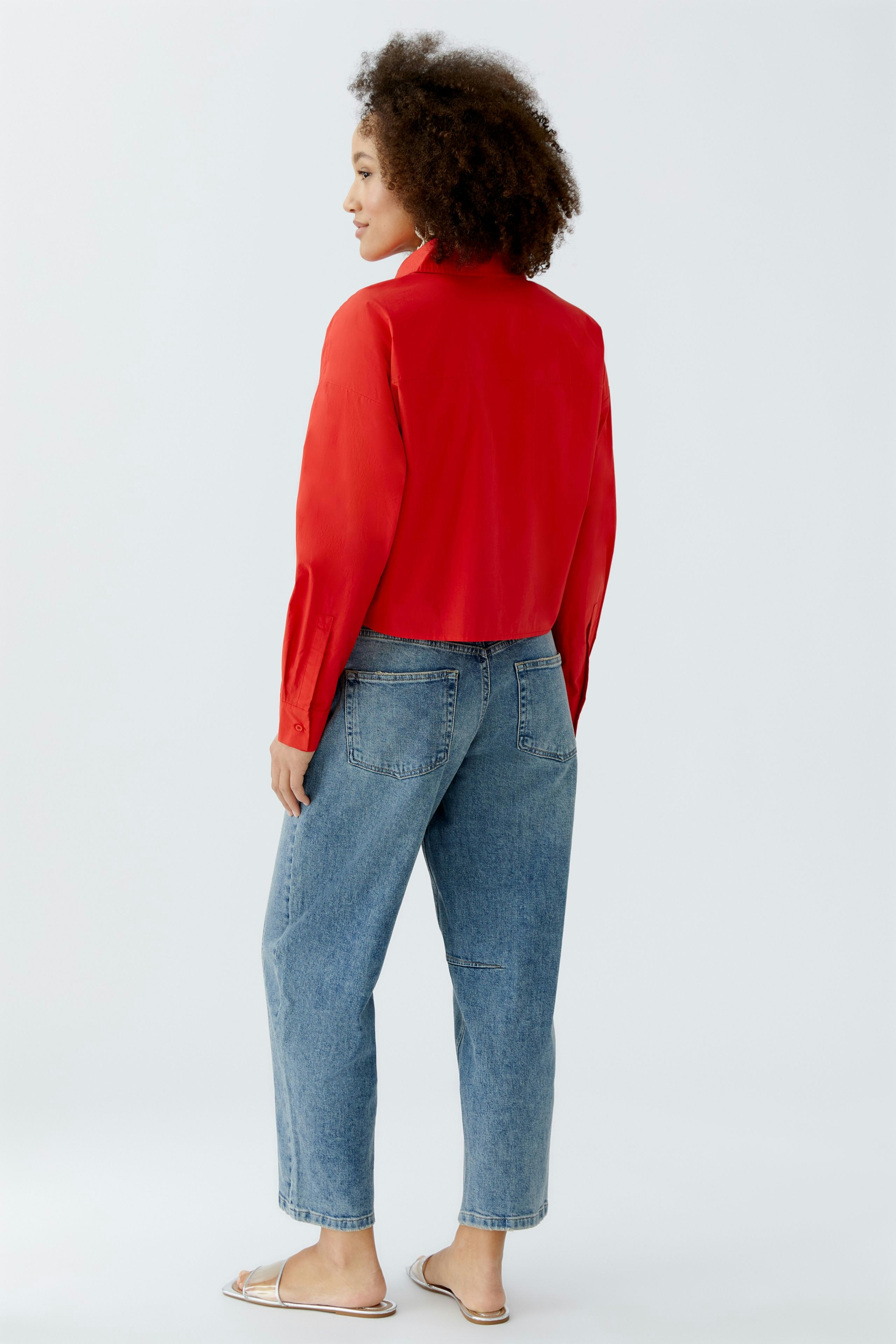 Rote Damen-Bluse mit langen Ärmeln, lässig kombiniert mit Jeans, von hinten sichtbar.