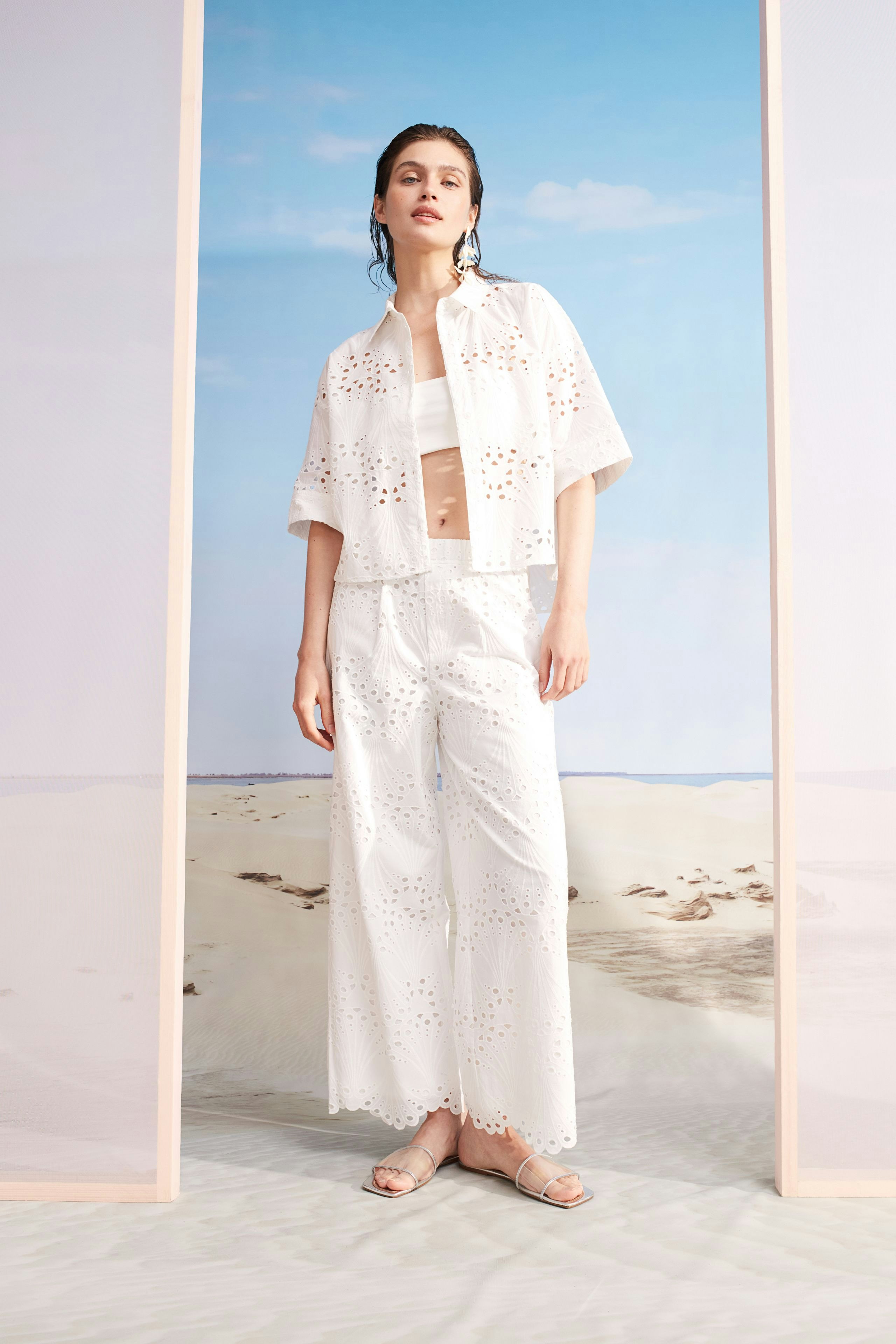 Lightweight women's blouse with eyelet details, paired with wide-leg pants, perfect for summer.