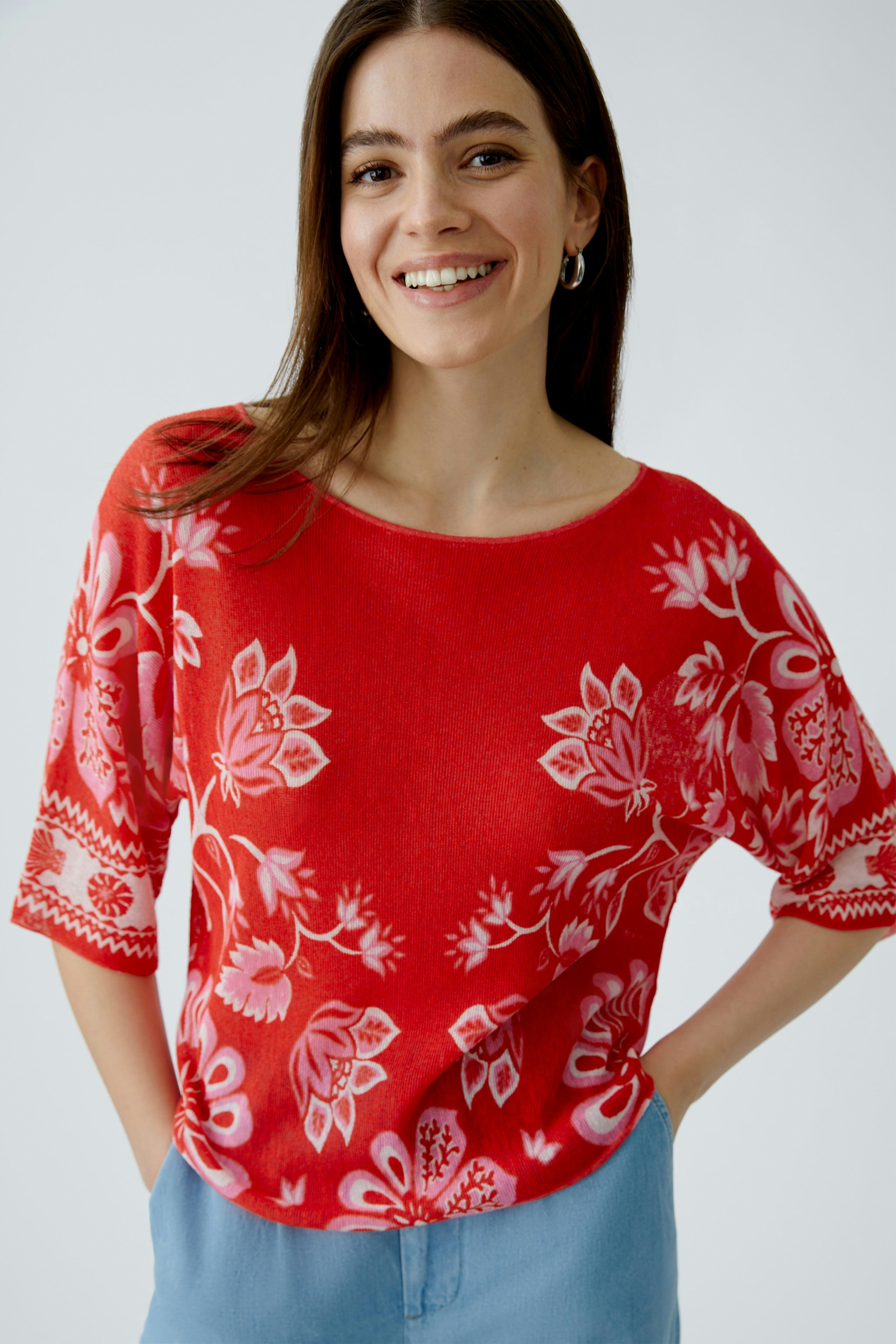 Casual women's pullover: Smiling woman in a red floral pullover with three-quarter sleeves.