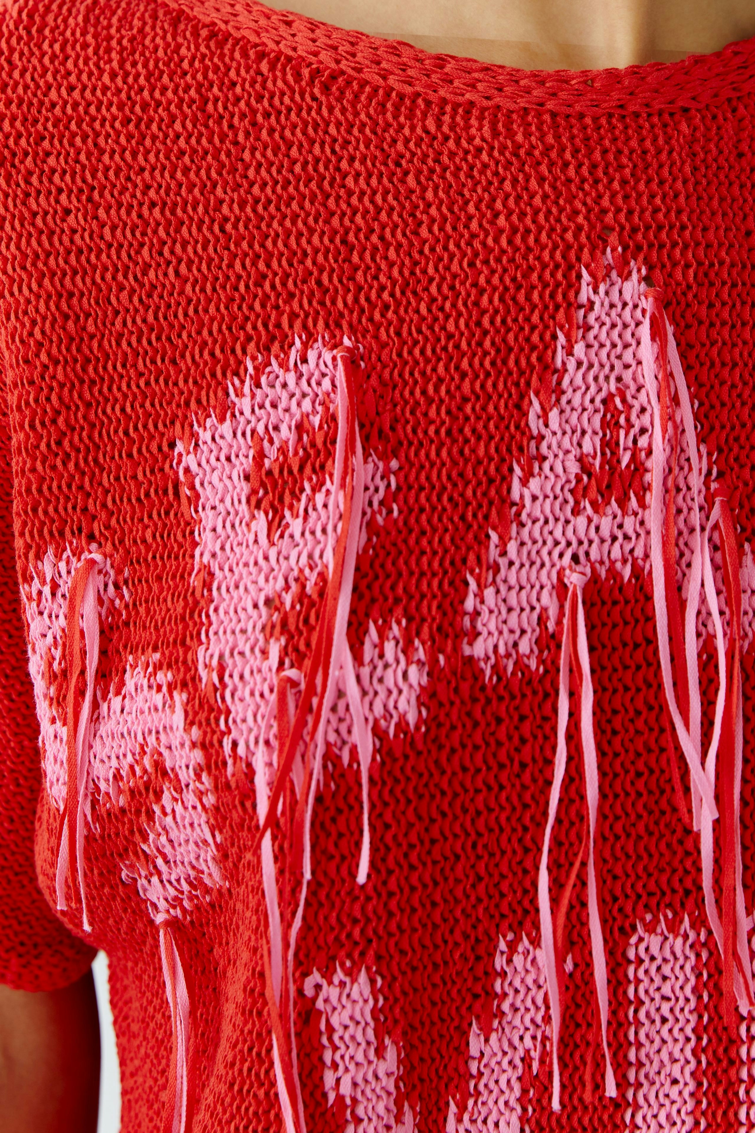 Casual women's pullover: Close-up of a red knit pullover with playful fringes and bold lettering.