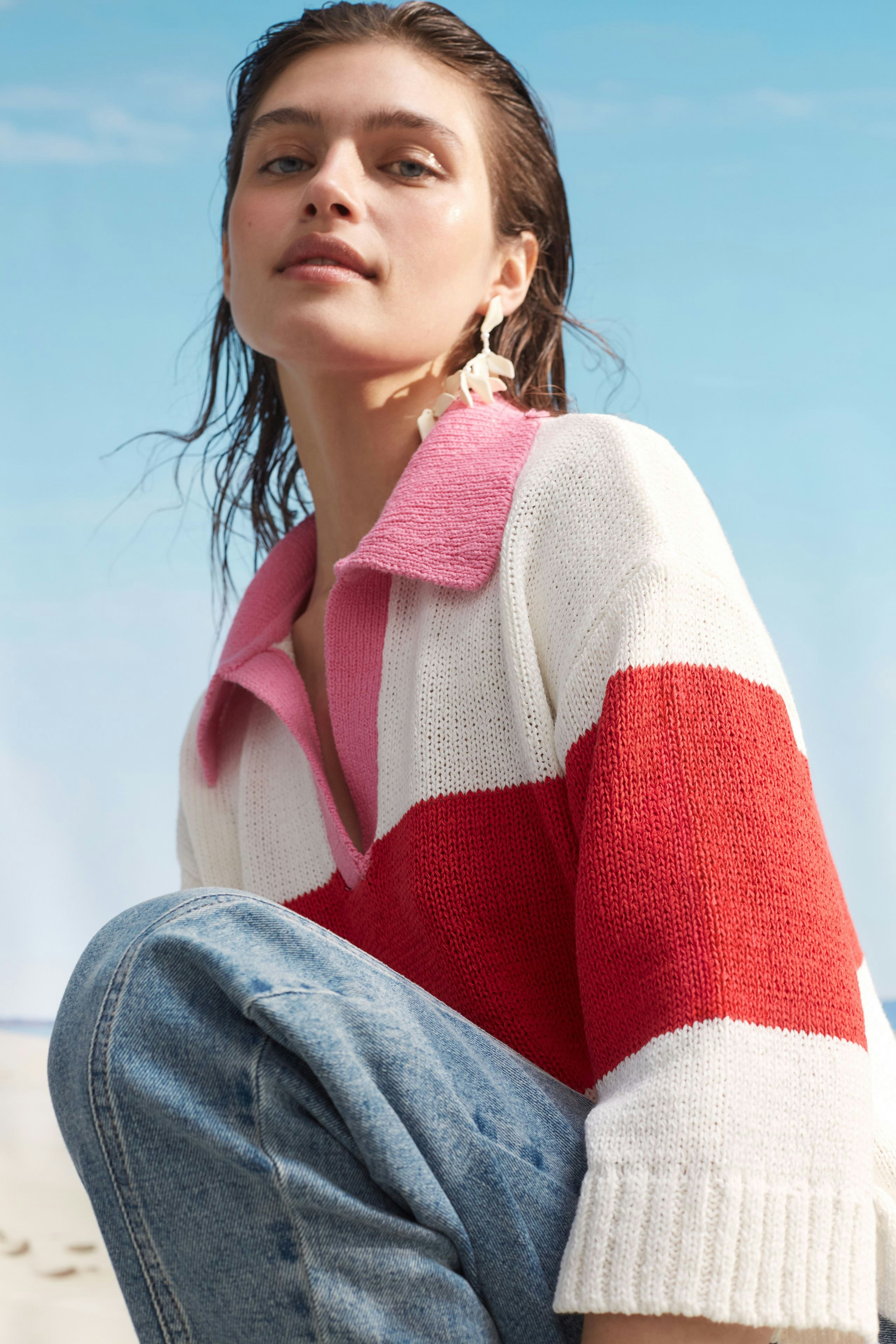Casual women's pullover: Young woman in a striped knit pullover with a pink collar and relaxed fit.
