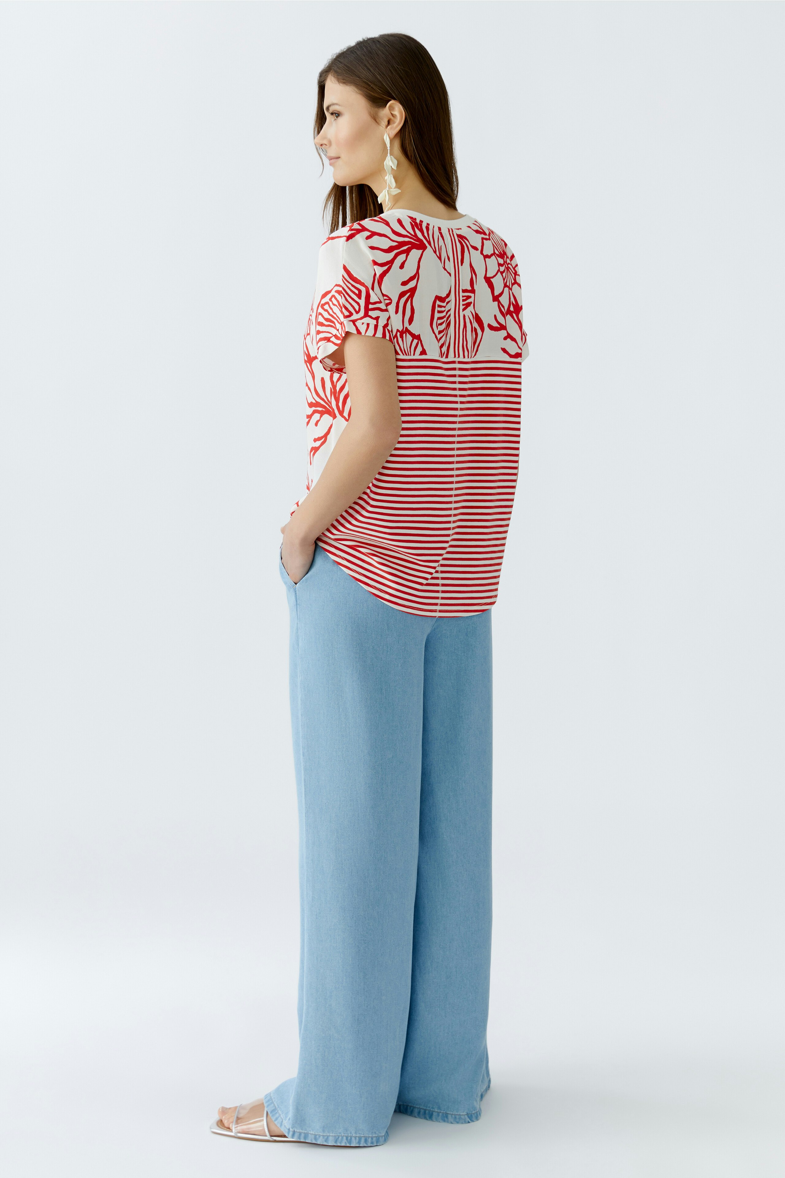 Casual women's blouse shirt: A woman in a striped red and white blouse with a relaxed fit.