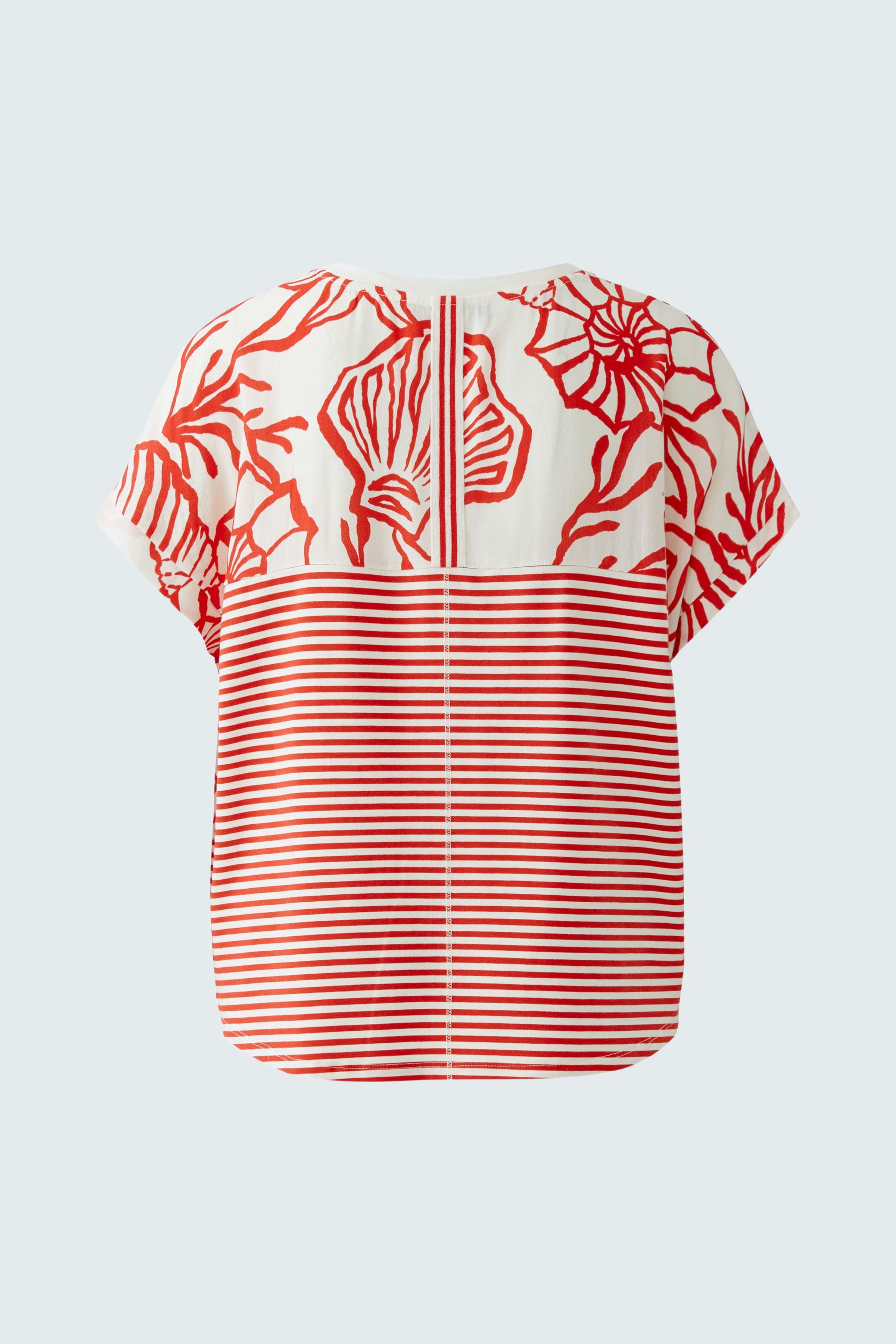 Casual women's blouse shirt: A woman in a colorful top with floral and striped patterns.