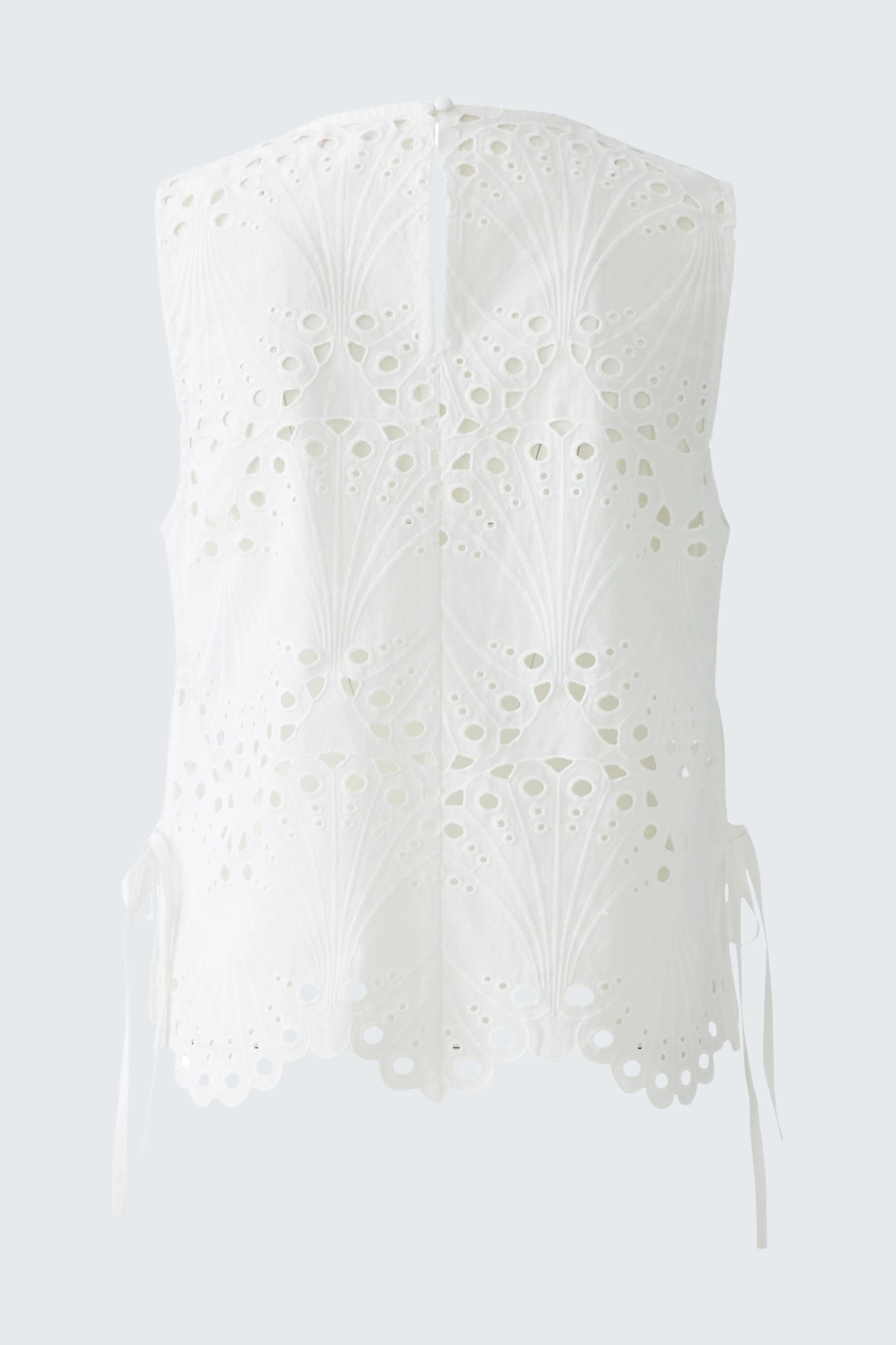 Stylish women's top: White sleeveless top with intricate cut-out details and adjustable ties at the sides.